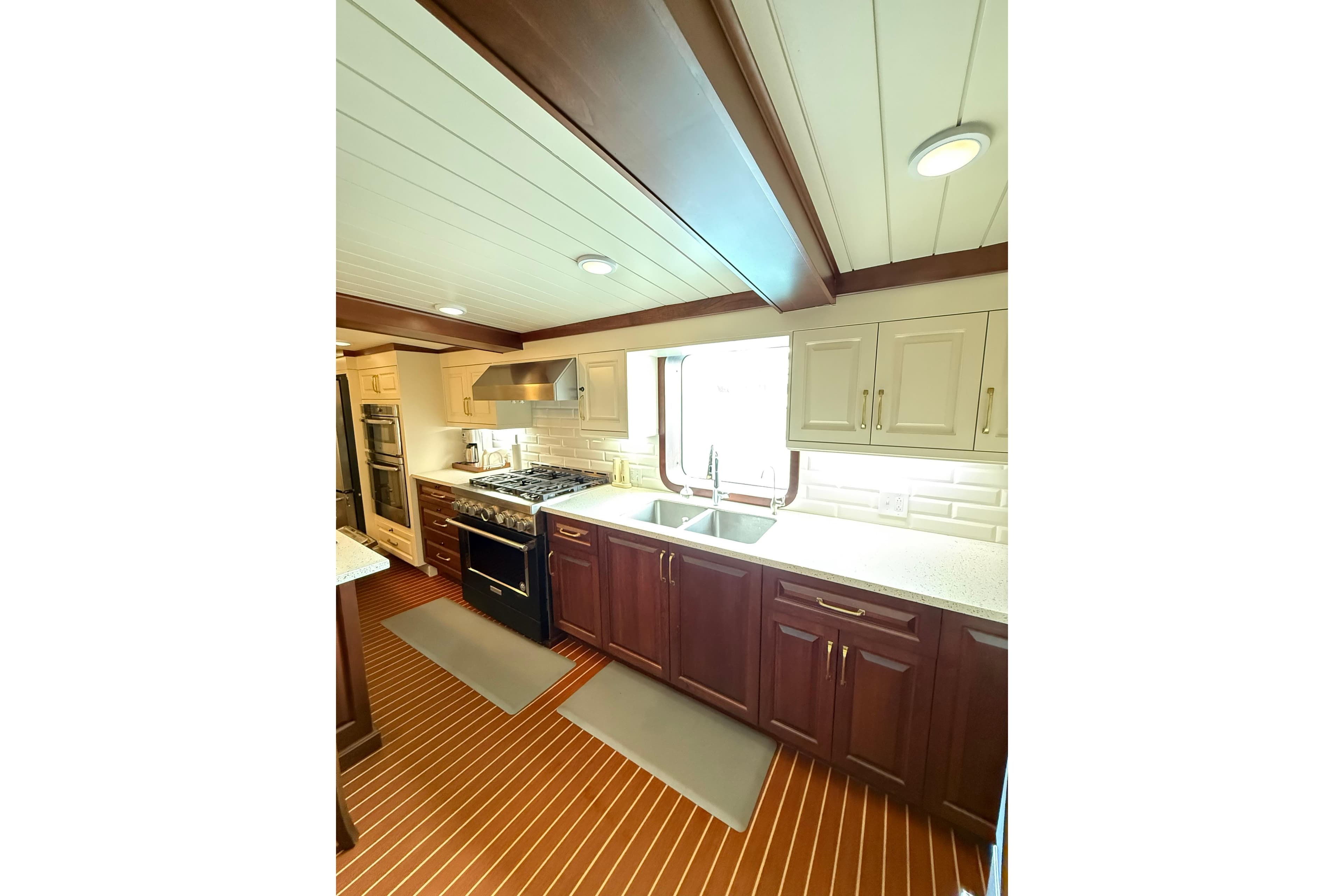 Luxurious ship kitchen with modern appliances, wooden cabinetry, and elegant design, Glovertown Shipyard 2021.