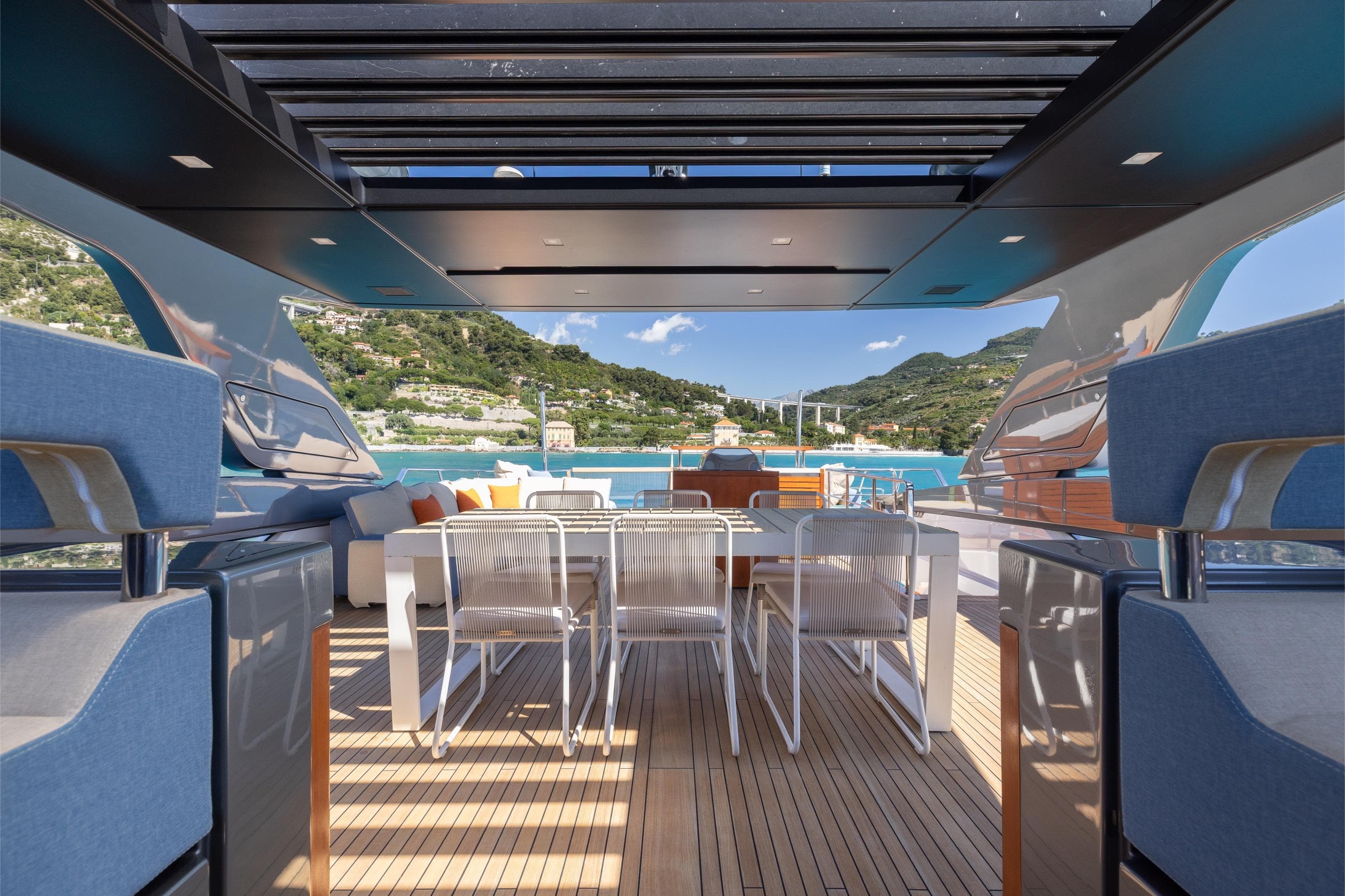 Luxurious 2022 Sanlorenzo SL106A yacht deck with elegant seating and scenic coastal view.