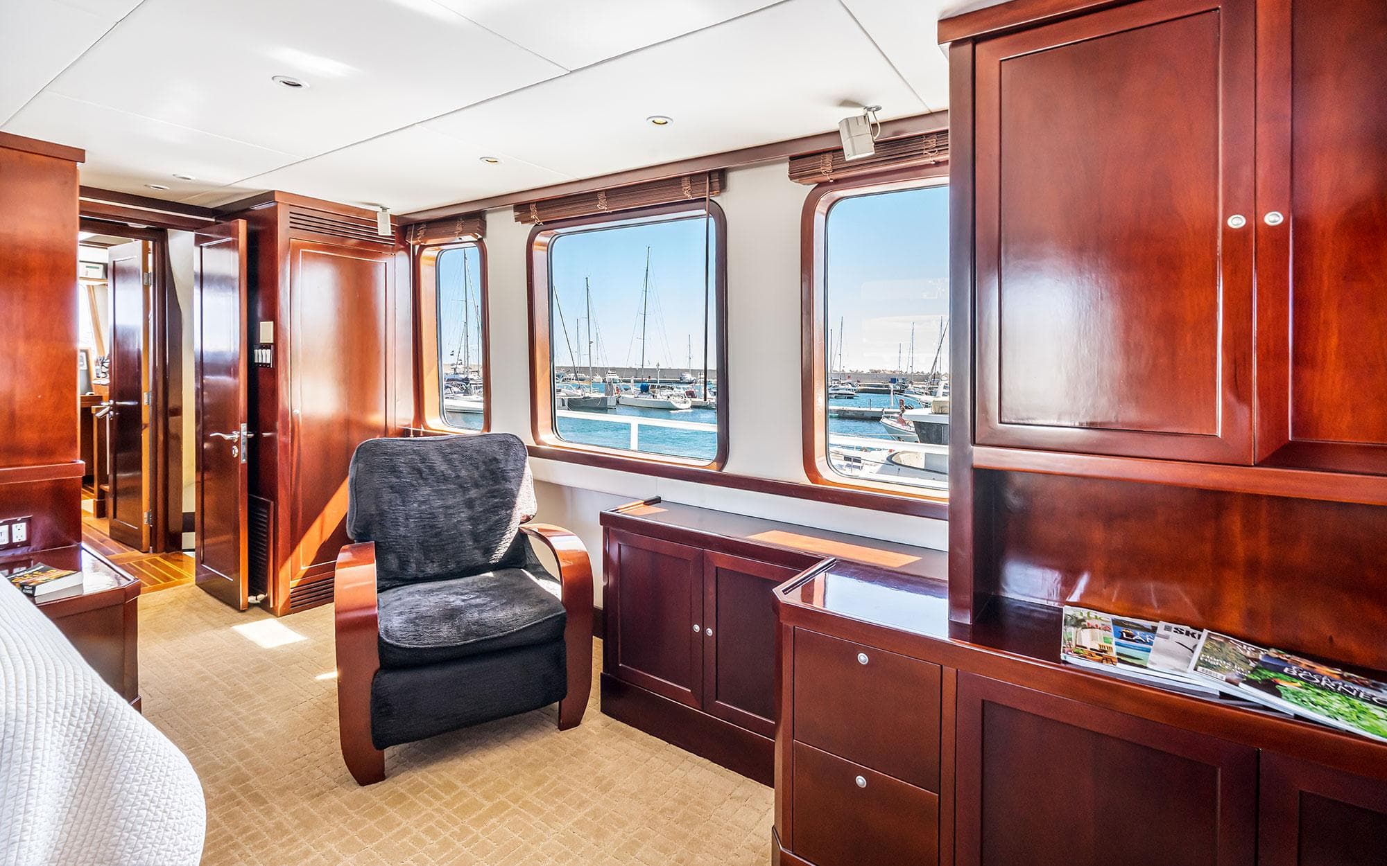Luxurious 2003 Inace Pilothouse Yacht interior with elegant wood finishes and marina view.