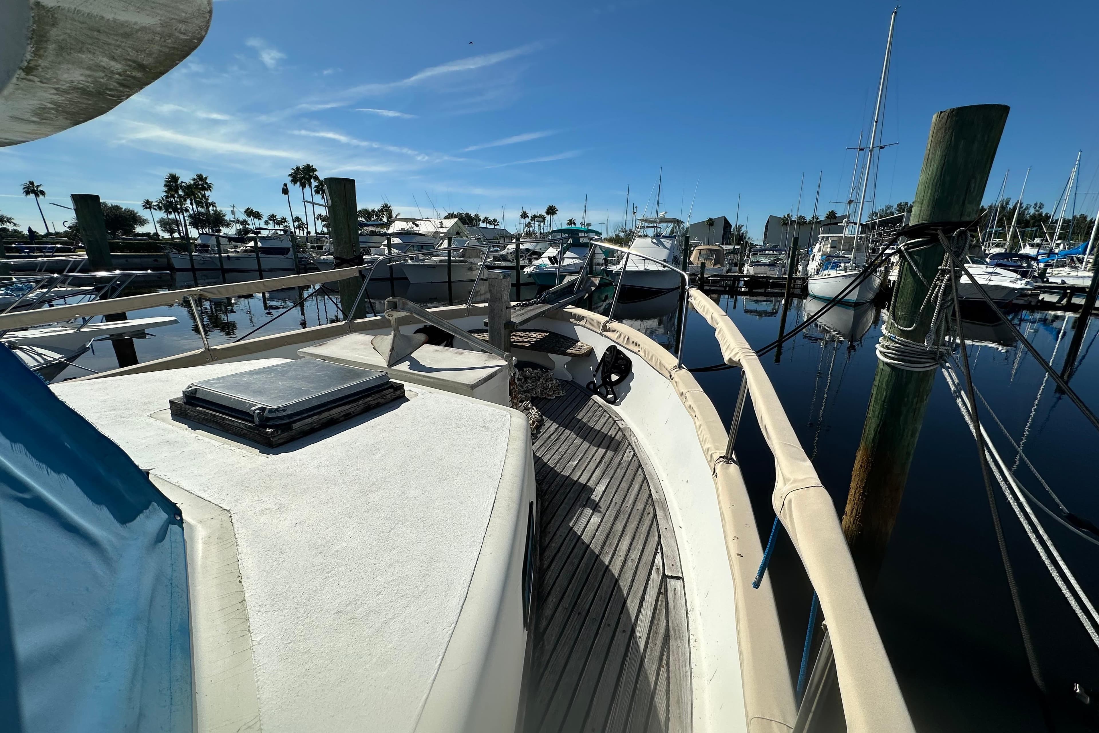 1979 Marine Trader 38DC yacht docked at a marina under clear blue skies.