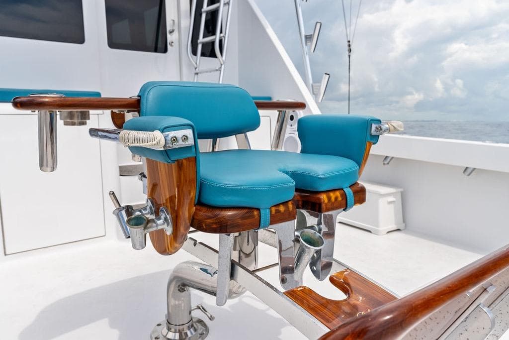 Luxurious fishing chair on 2005 Viking 61 Convertible yacht, featuring blue cushions and wooden accents.