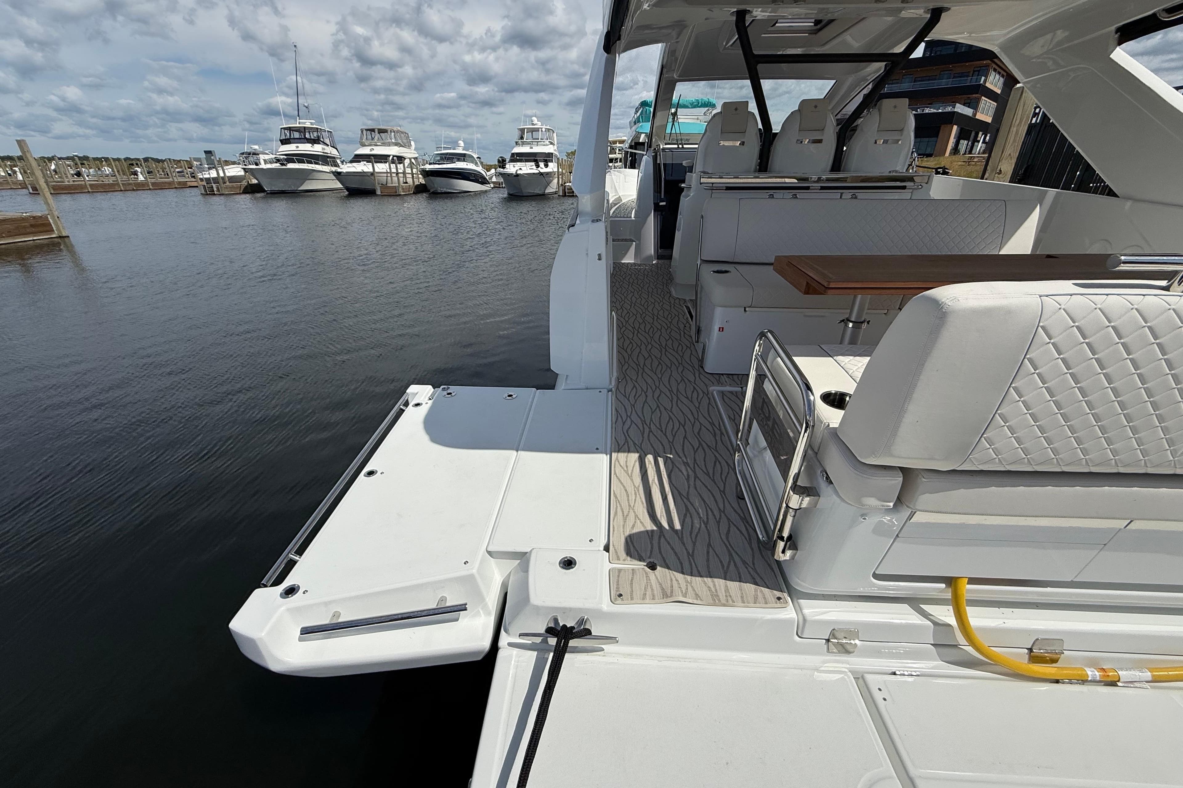 2026 Jeanneau DB/37 OB boat interior with seating and table, docked at marina.