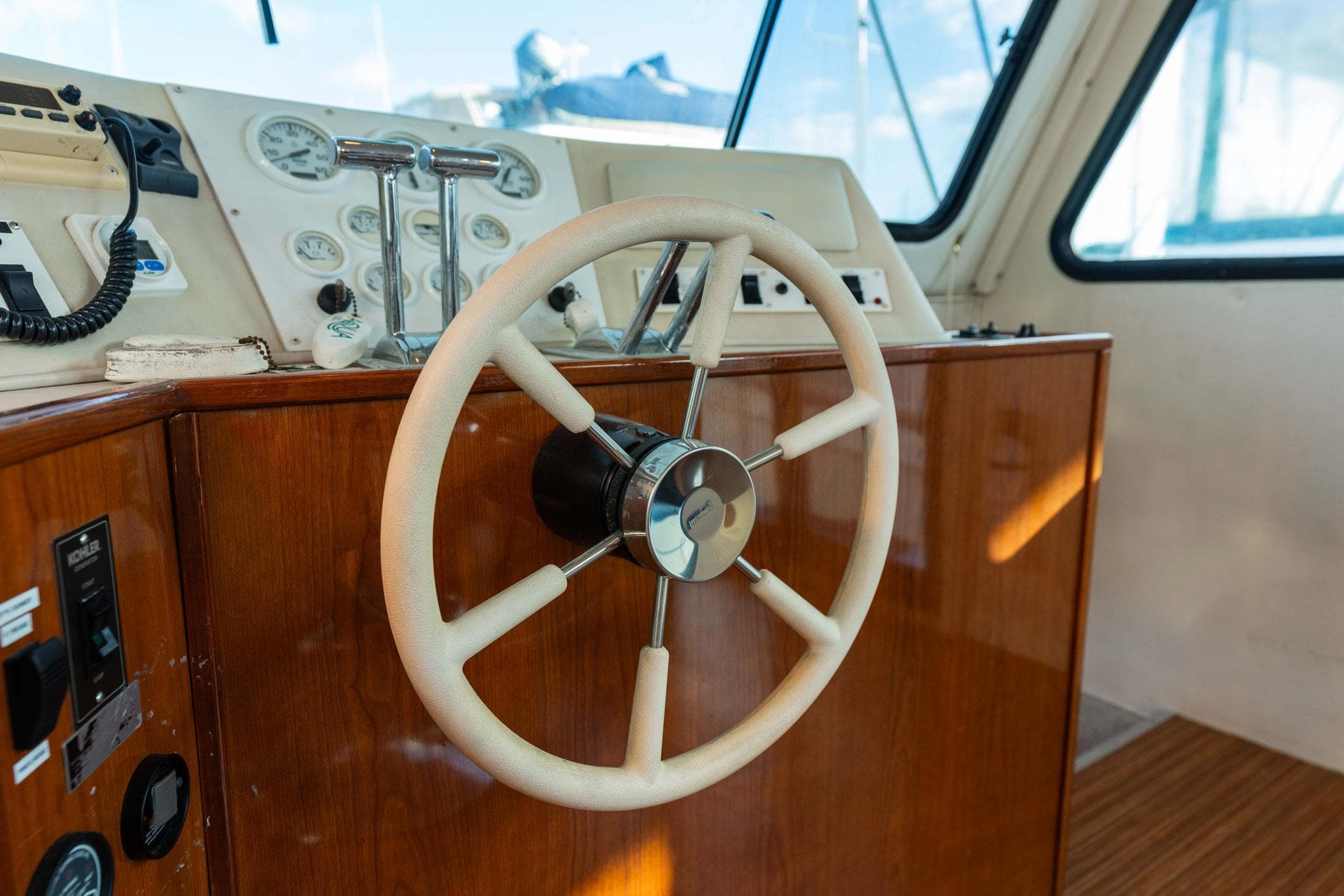Steering wheel of a 2001 Harbor Master 520 Coastal boat, featuring wooden dashboard controls.