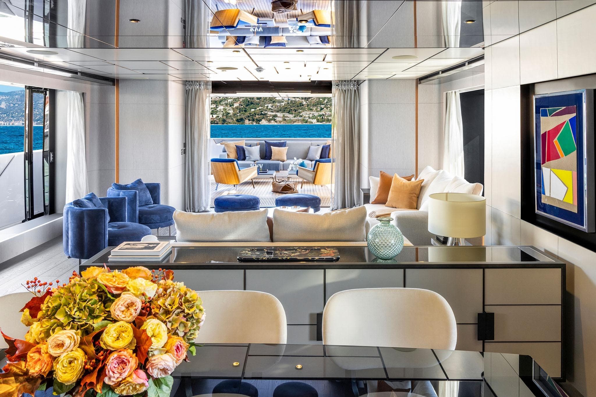 Luxurious yacht interior with modern decor, vibrant seating, and ocean view, Custom Line CL 140, 2022.