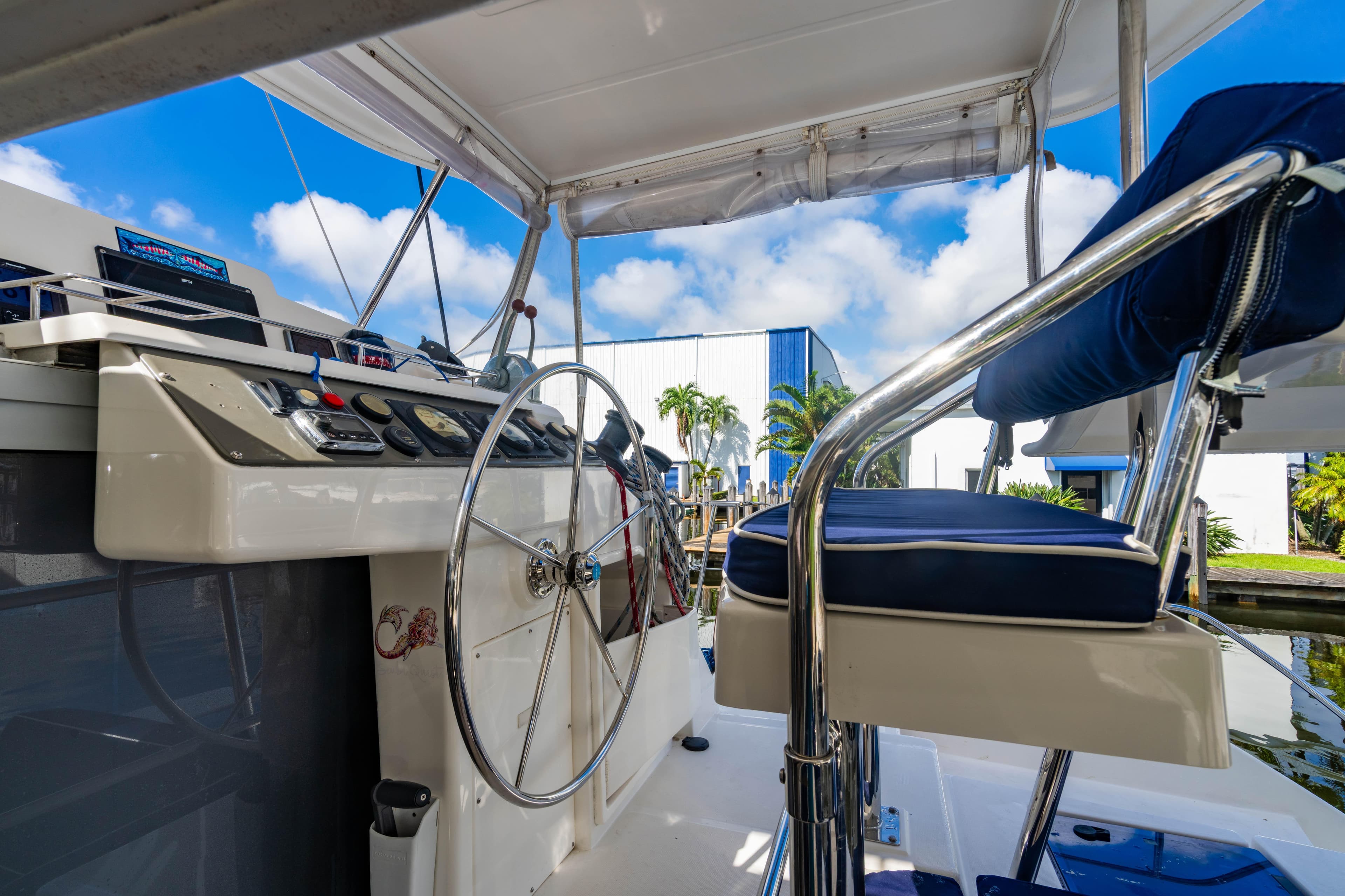 Helm of 2016 Leopard 40 catamaran with steering wheel and controls, under blue sky.