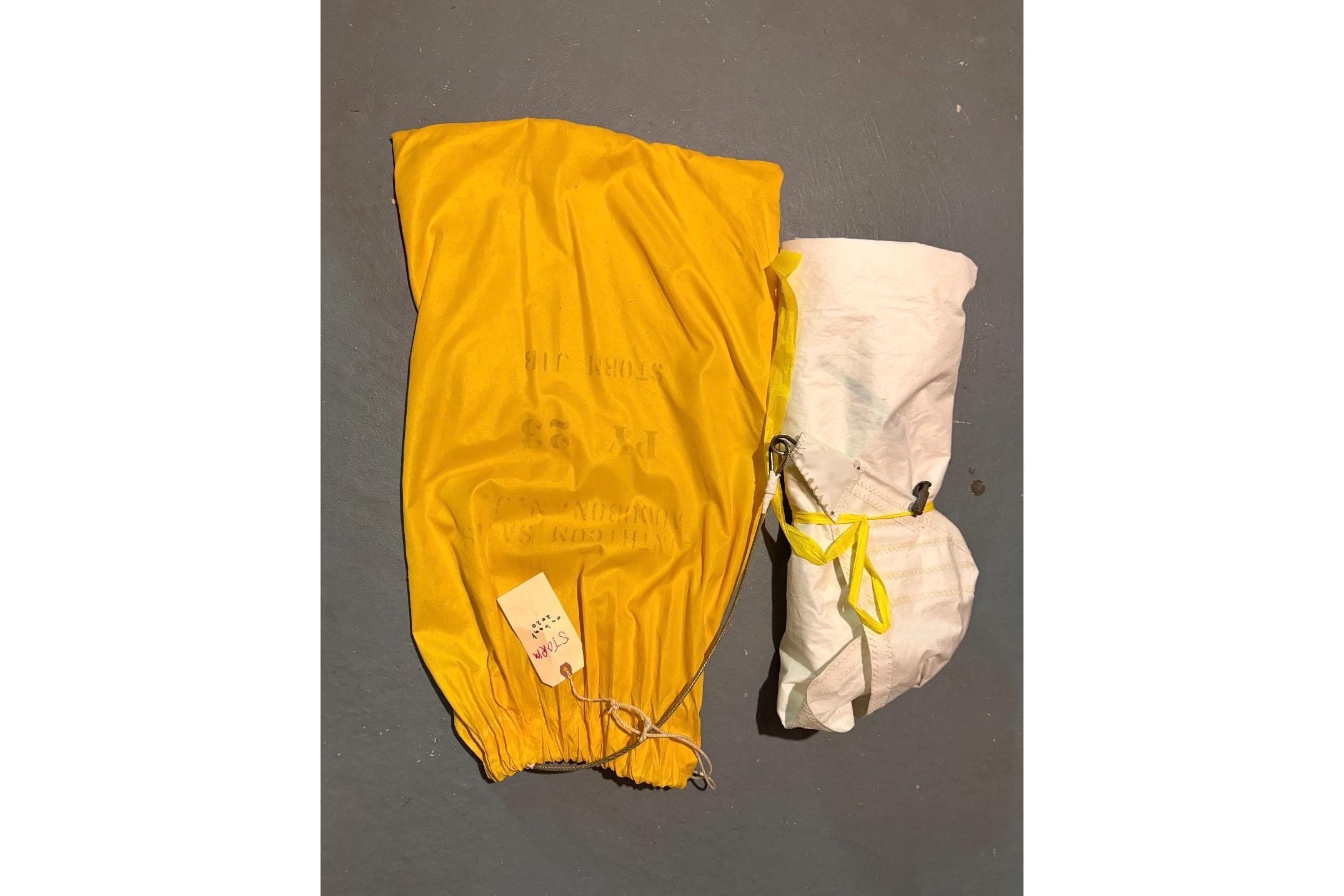 Yellow and white PAC 23 parachute from 1976, neatly packed with label attached.