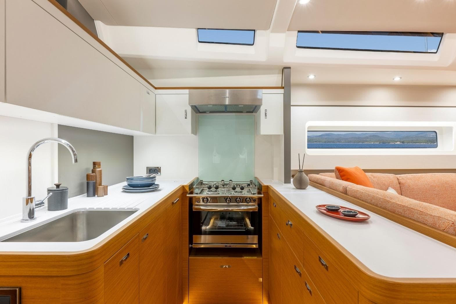 Luxurious interior of 2026 Beneteau First 60 yacht, featuring modern kitchen and cozy seating area.