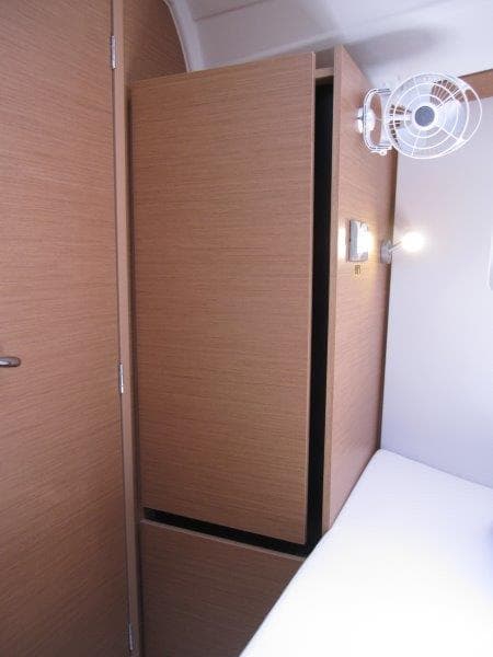 2025 Jeanneau Sun Odyssey 350 interior cabin with wooden cabinetry and wall-mounted fan.