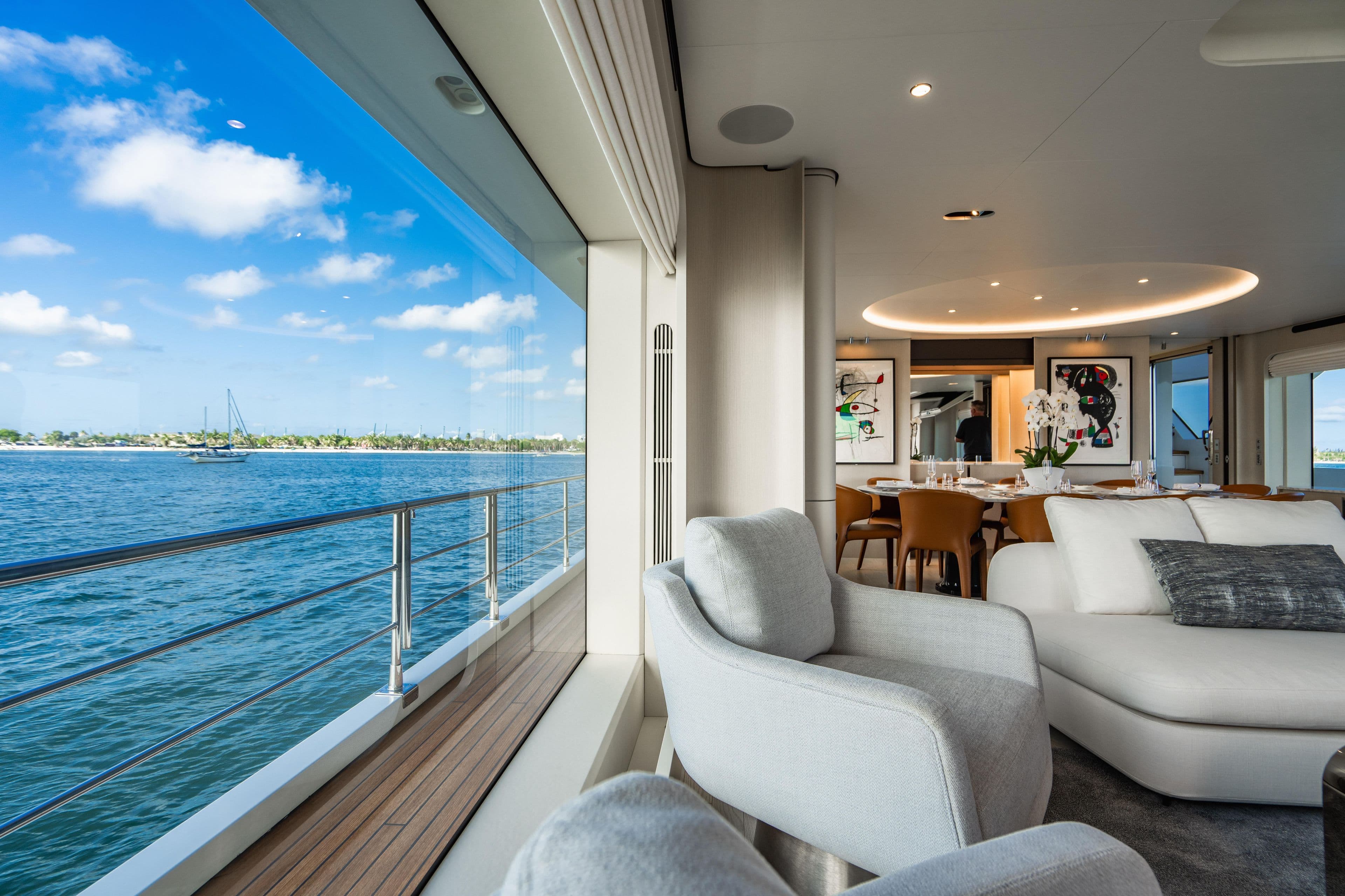 Luxurious 2023 Azimut yacht interior with ocean view, modern decor, and elegant dining area.