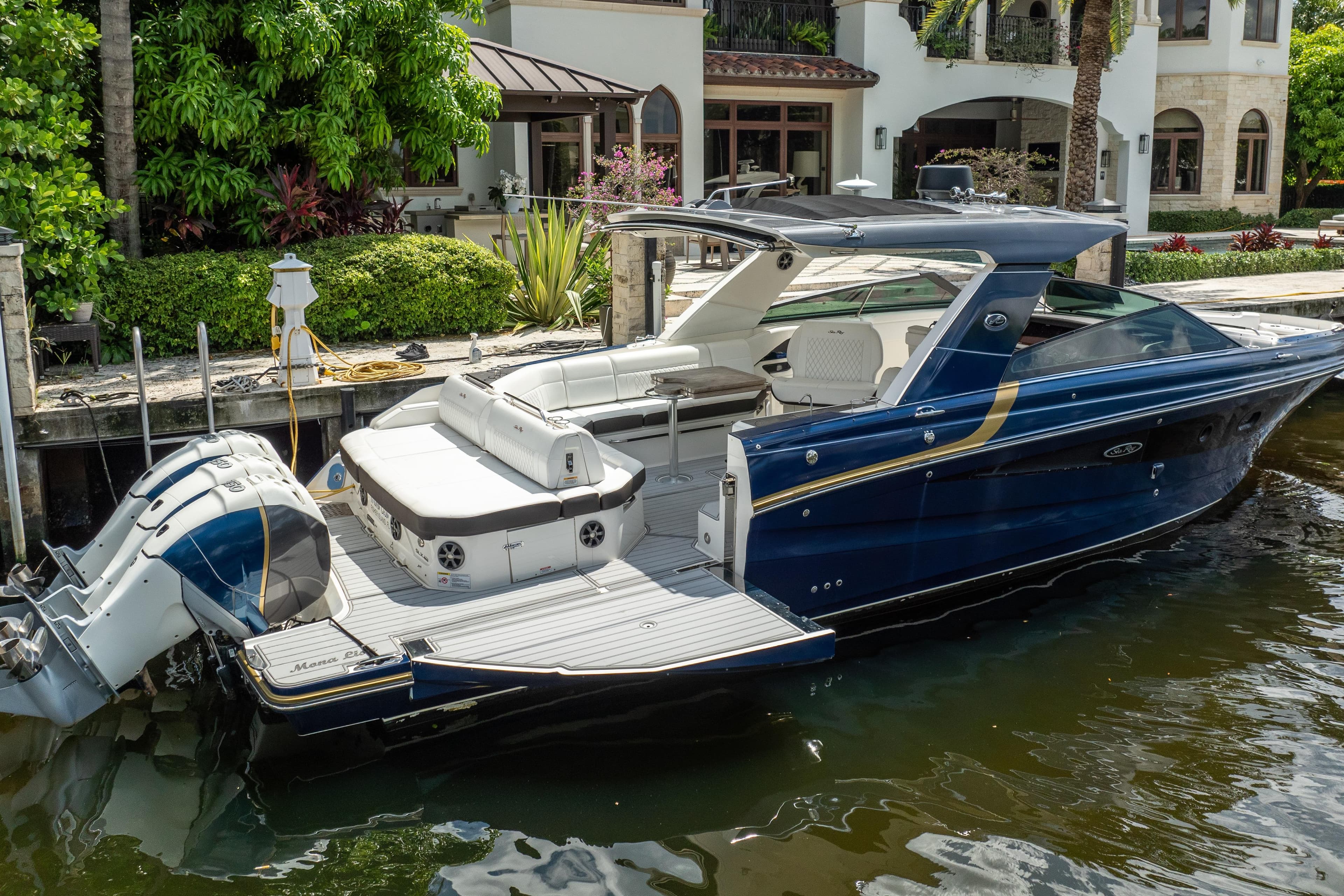 2019 Sea Ray SLX 400 Outboard luxury boat docked by waterfront home.