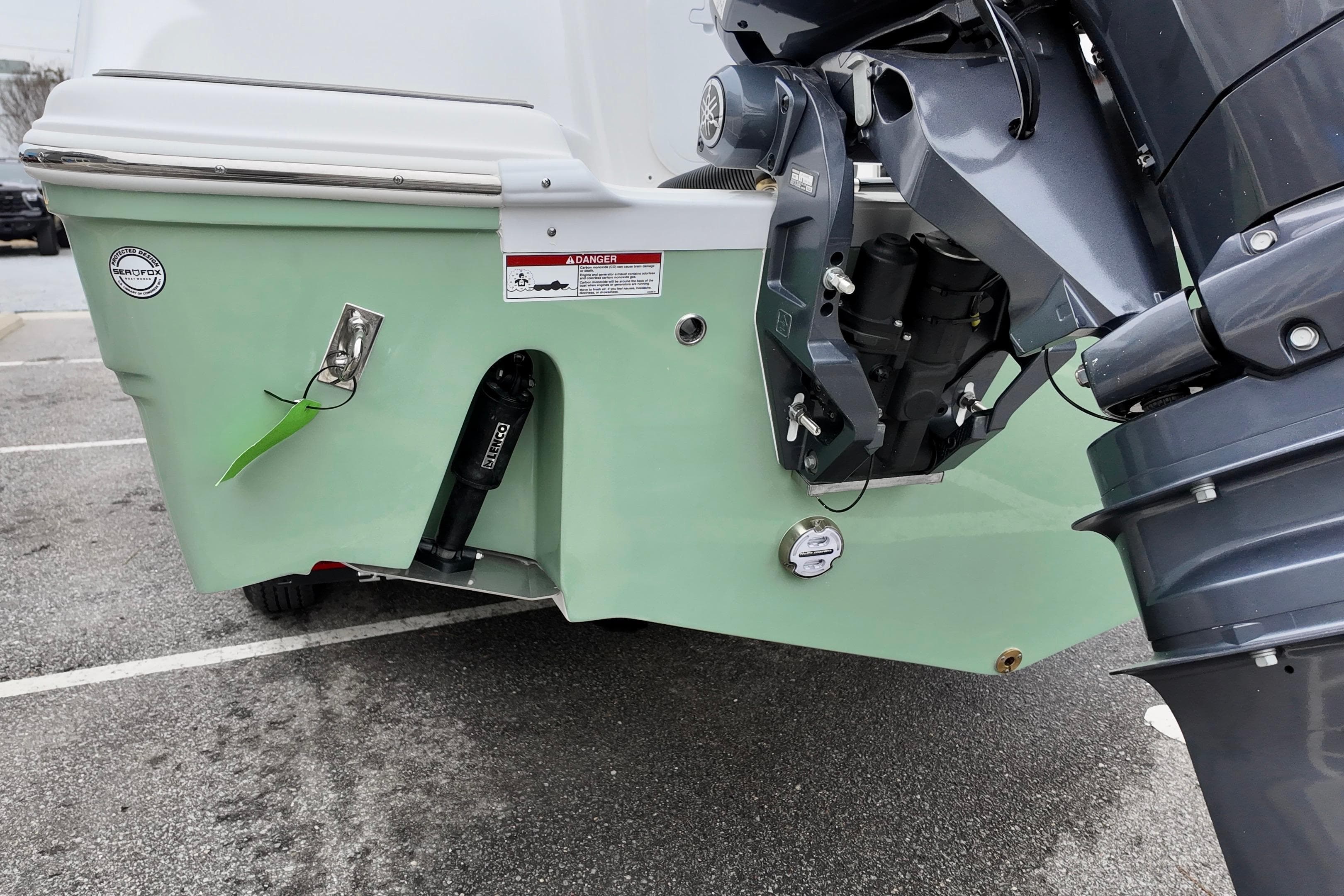 2026 Sea Fox 268 Commander boat stern with outboard motor in parking lot.