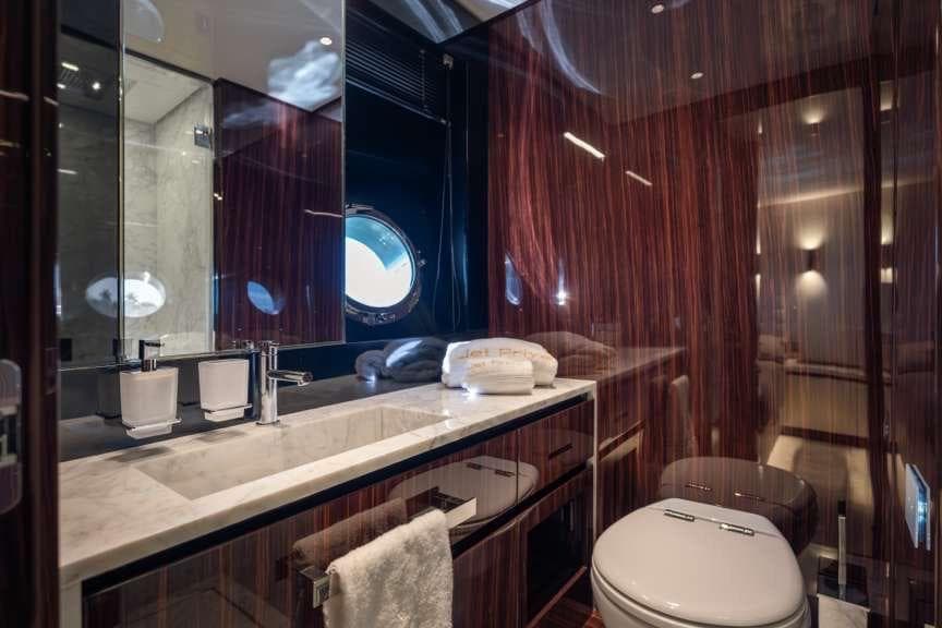 Luxurious bathroom interior of 2026 Riva 82' Diva yacht with elegant wood finish.