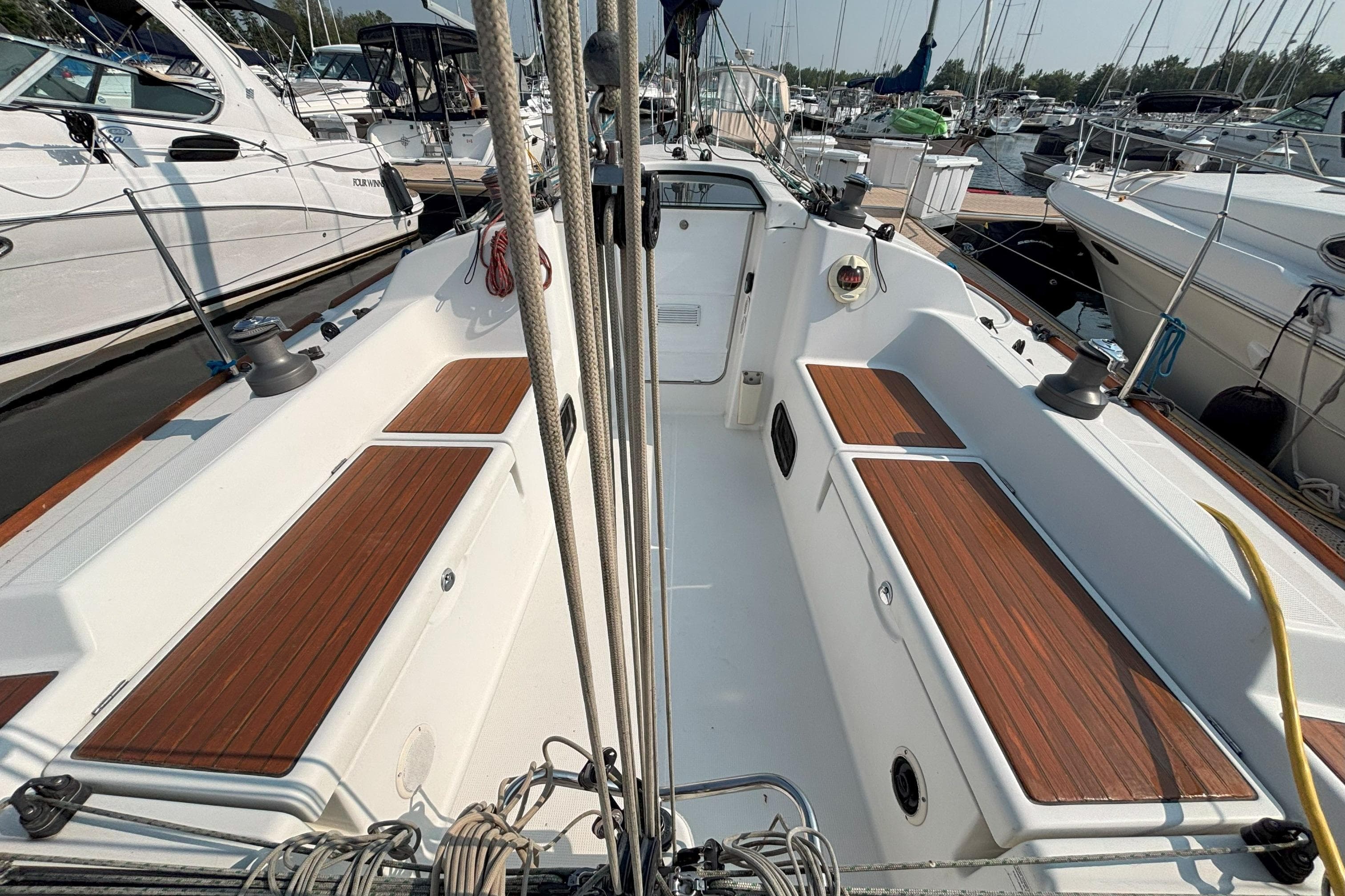 2008 Beneteau First 10R sailboat cockpit with wooden seating, docked in a marina.