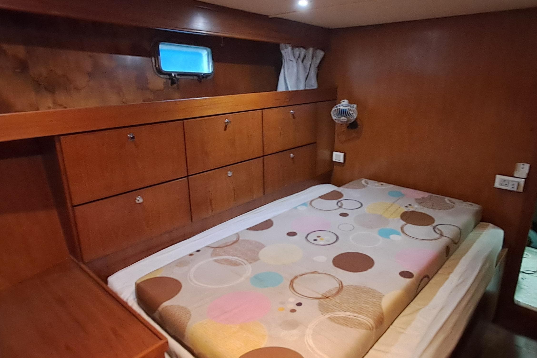 Cozy cabin interior of 2003 DeFever 57 POC yacht with wooden furnishings and single bed.