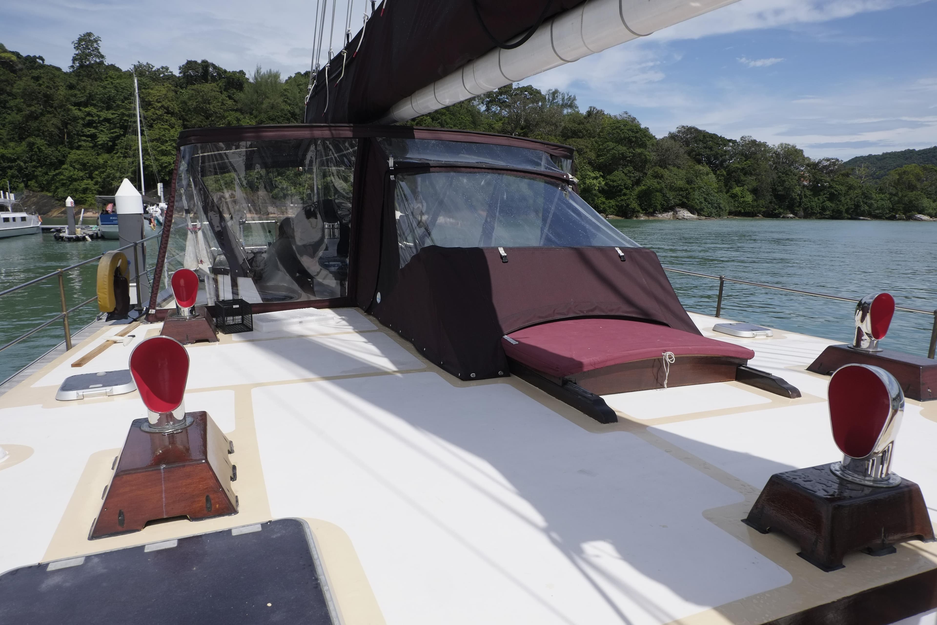 Custom Bud Macintosh schooner, 2006 model, docked in a serene bay with lush greenery.