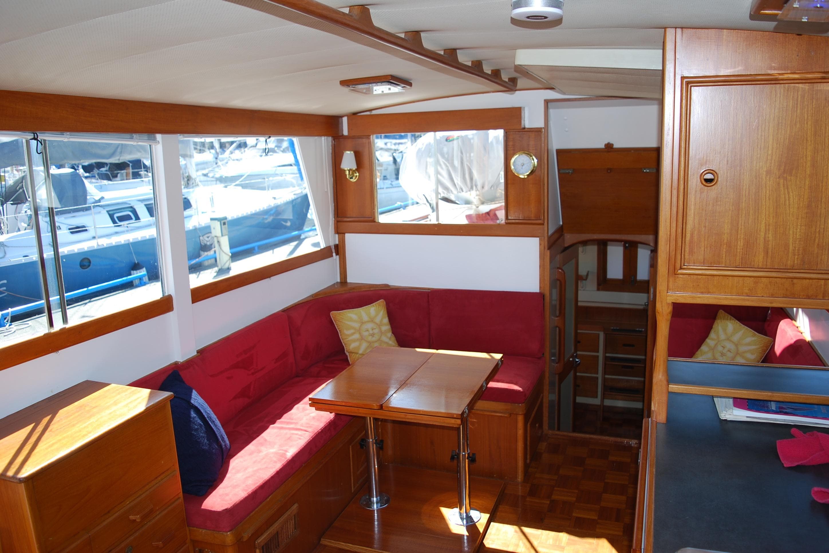 Interior of 1971 Grand Banks 36 Classic yacht with red seating and wooden furnishings.