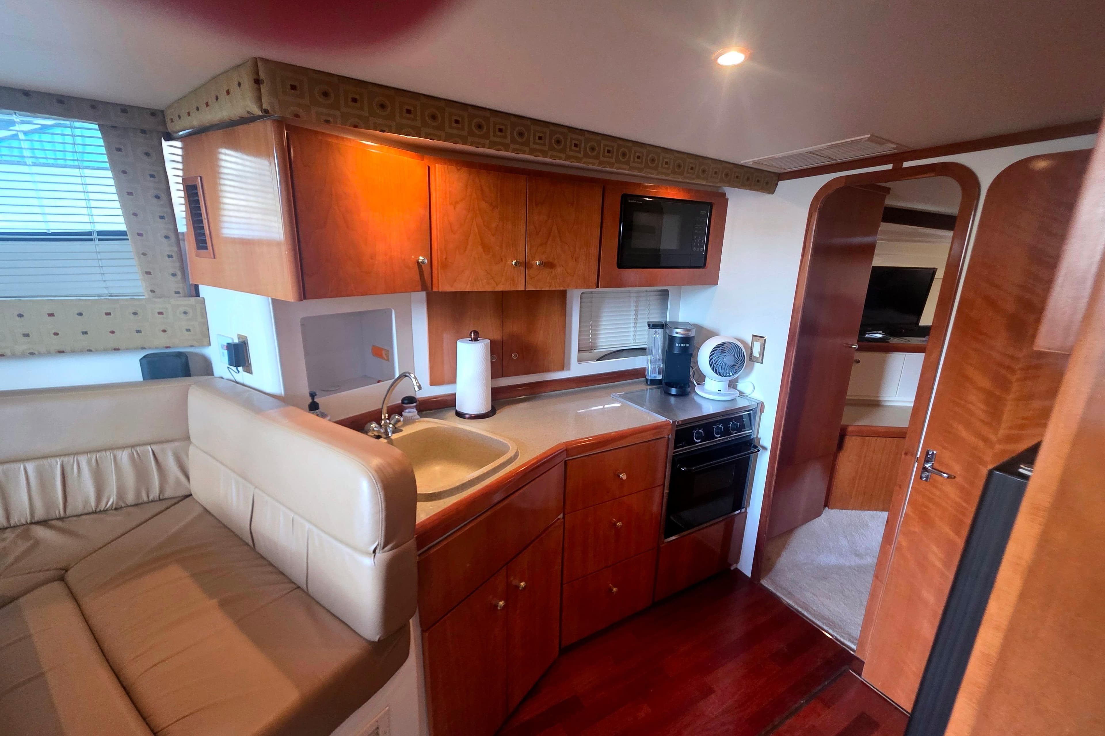 Interior of 2001 Carver 350 Mariner yacht featuring kitchen and seating area.