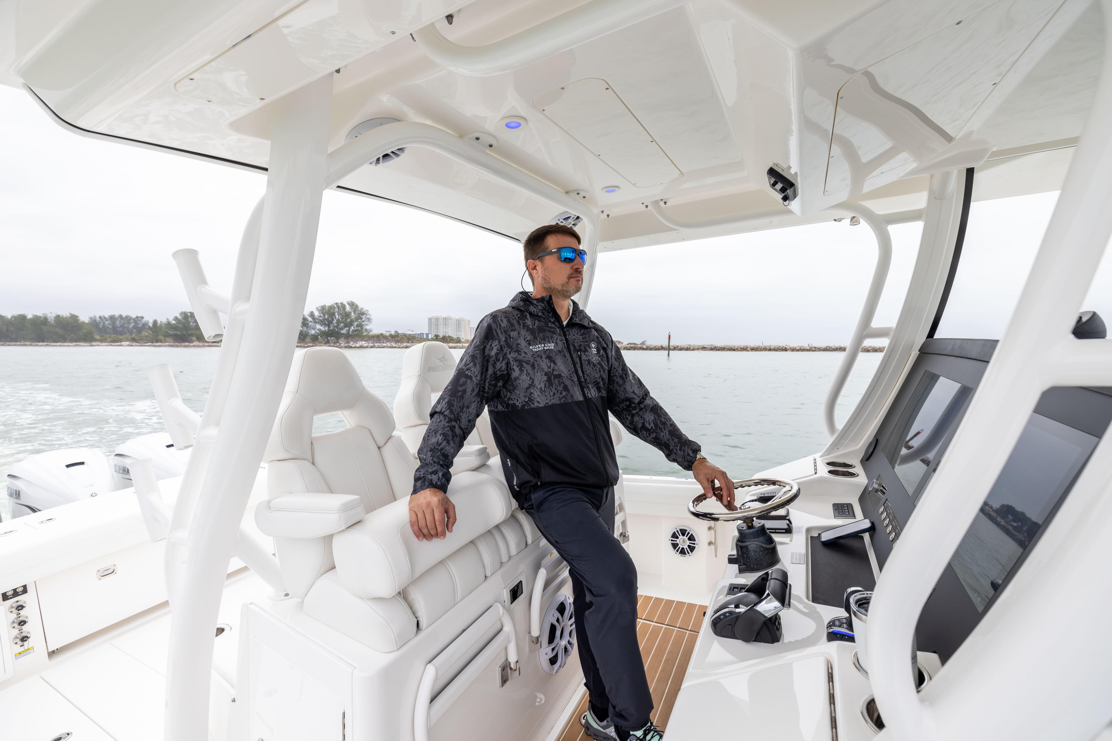 Man steering 2023 Regulator 37 boat on open water.