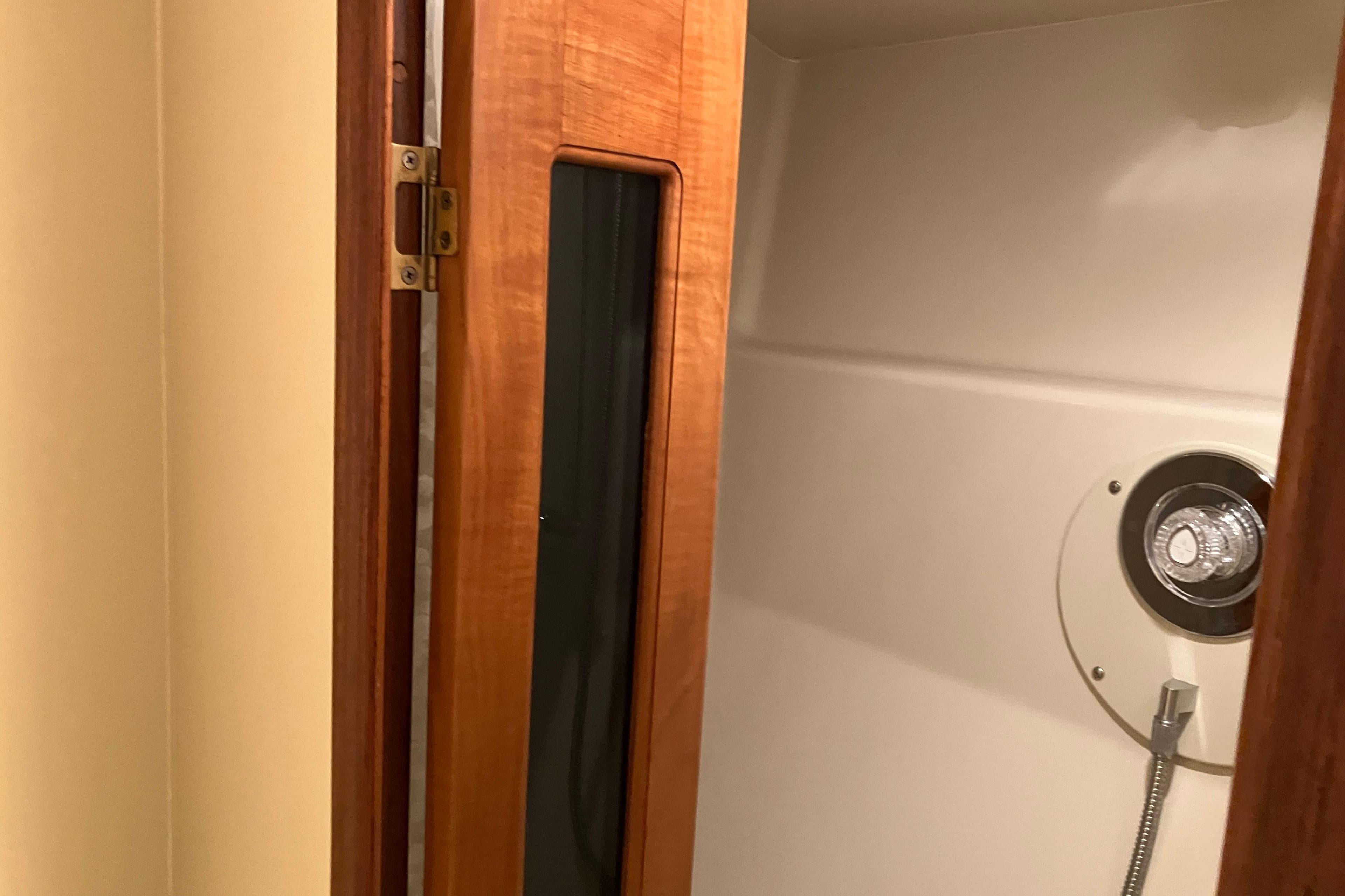 Shower area inside 1995 Viking 50 Motor Yacht with wooden door and chrome fixtures.