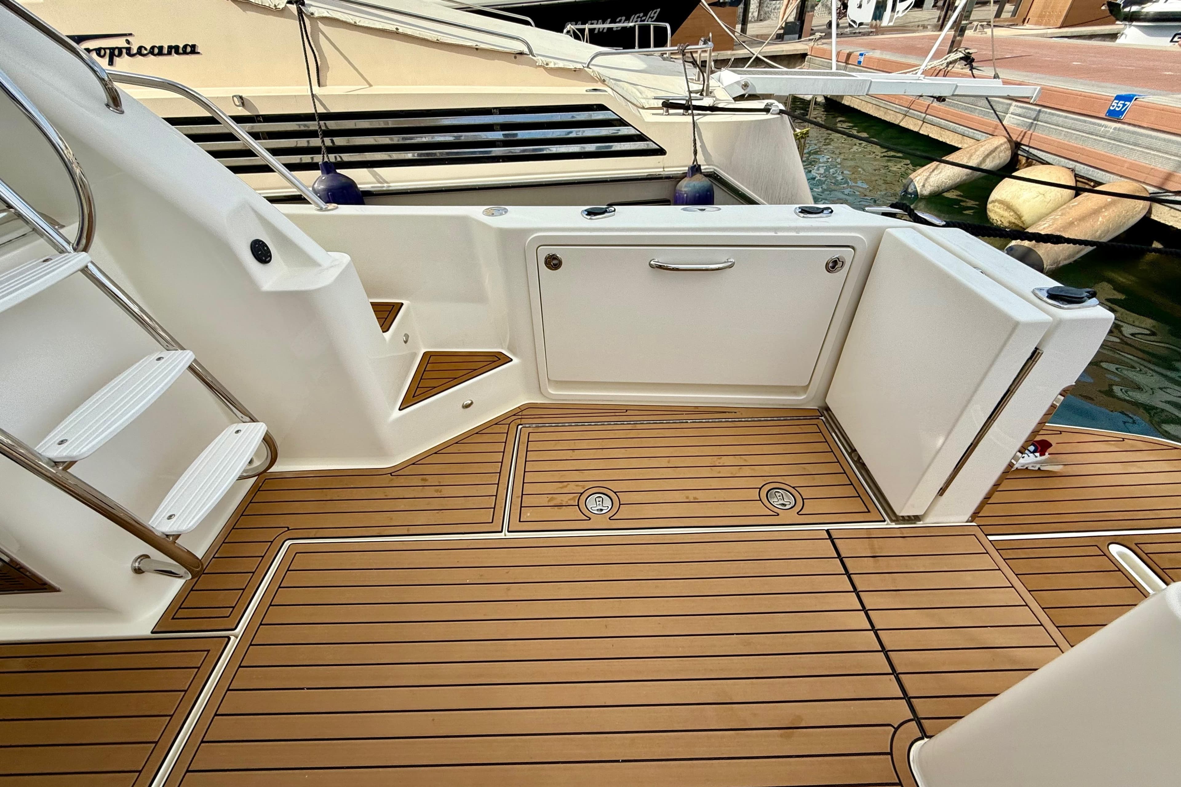 2019 Riviera 39 Sports Motor Yacht deck with teak flooring and stainless steel railings.