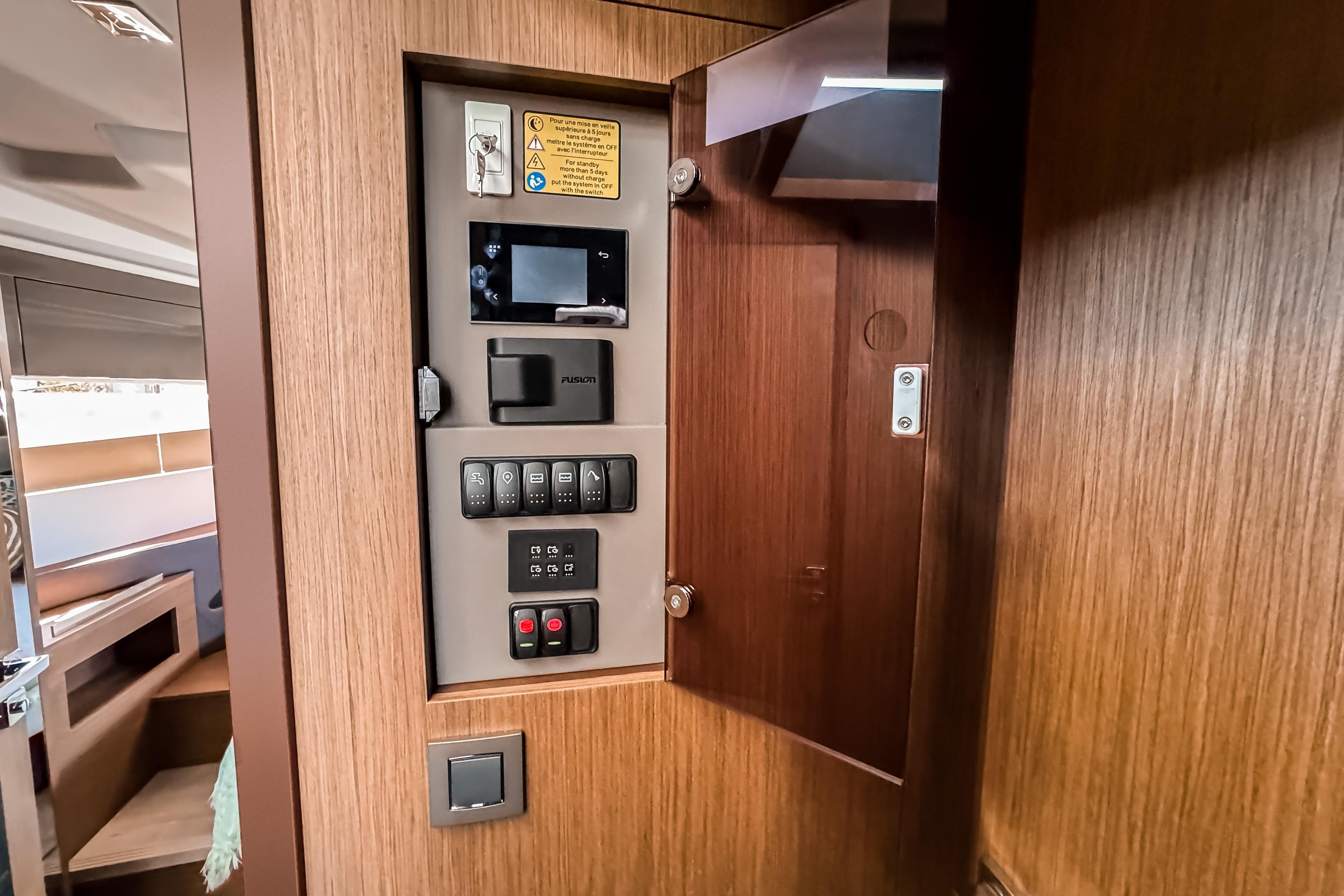 Control panel inside 2026 Wellcraft 44 Explorer yacht, featuring modern switches and wood finish.