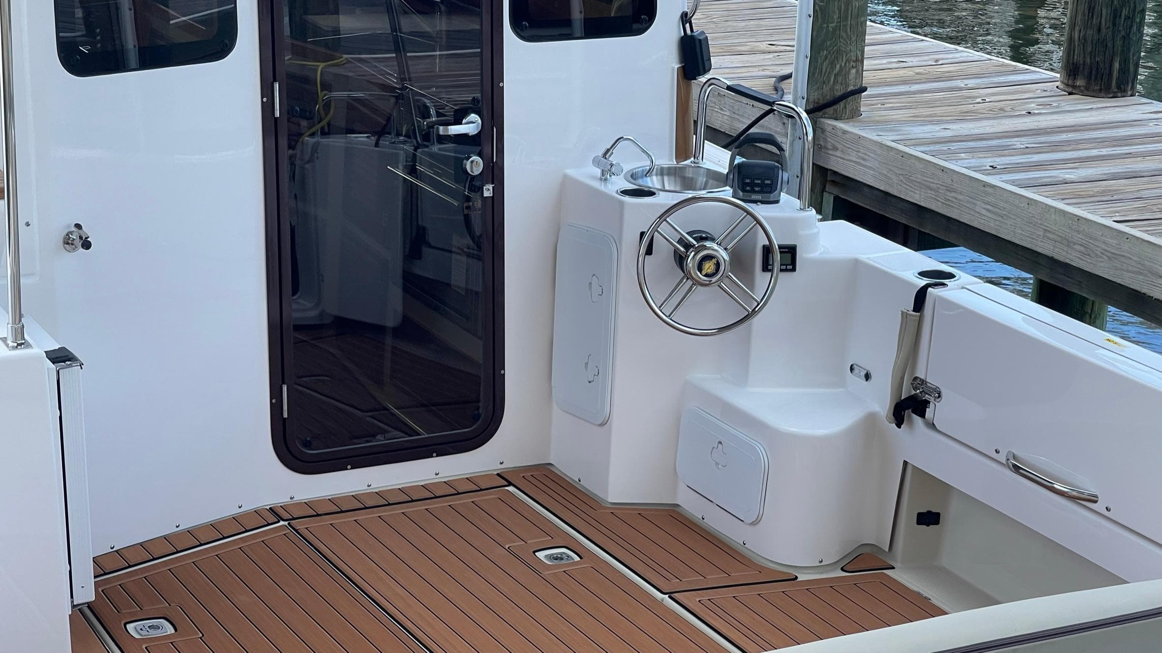 2025 Ranger Tugs R-31 CB boat cockpit with teak flooring and steering wheel.