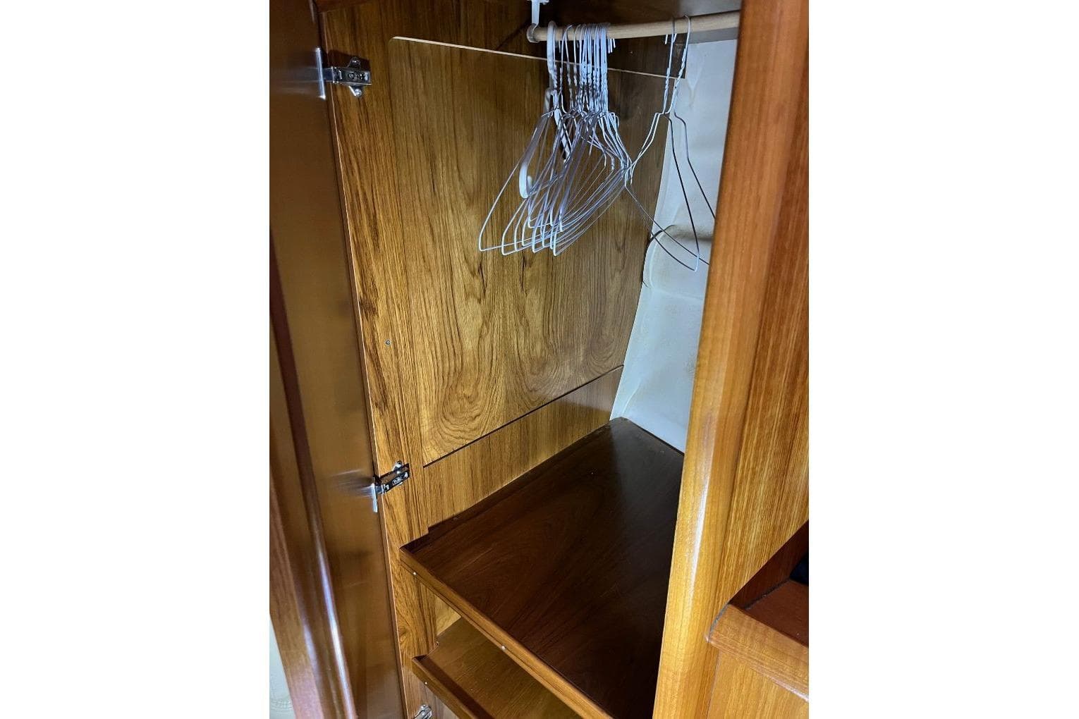 Wooden closet interior with hangers on Jeanneau Sun Odyssey 45, 2008 model.