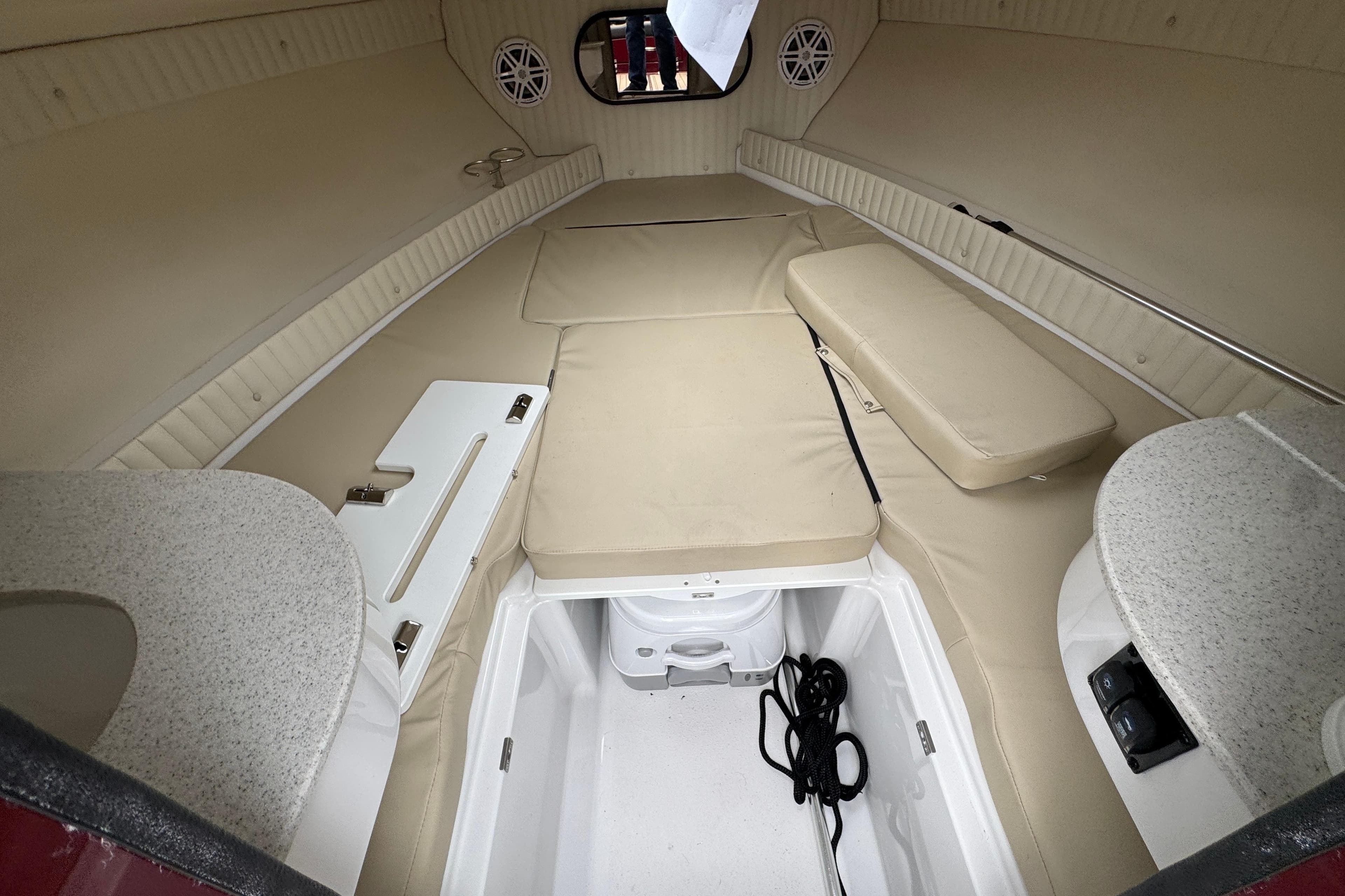 Interior cabin of 2026 Stingray 23 OCX boat with beige seating and storage.