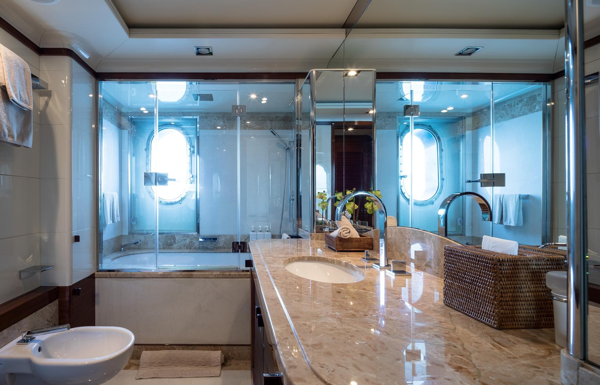 Luxurious bathroom on 2011 Benetti 60 yacht with marble countertop and glass shower.