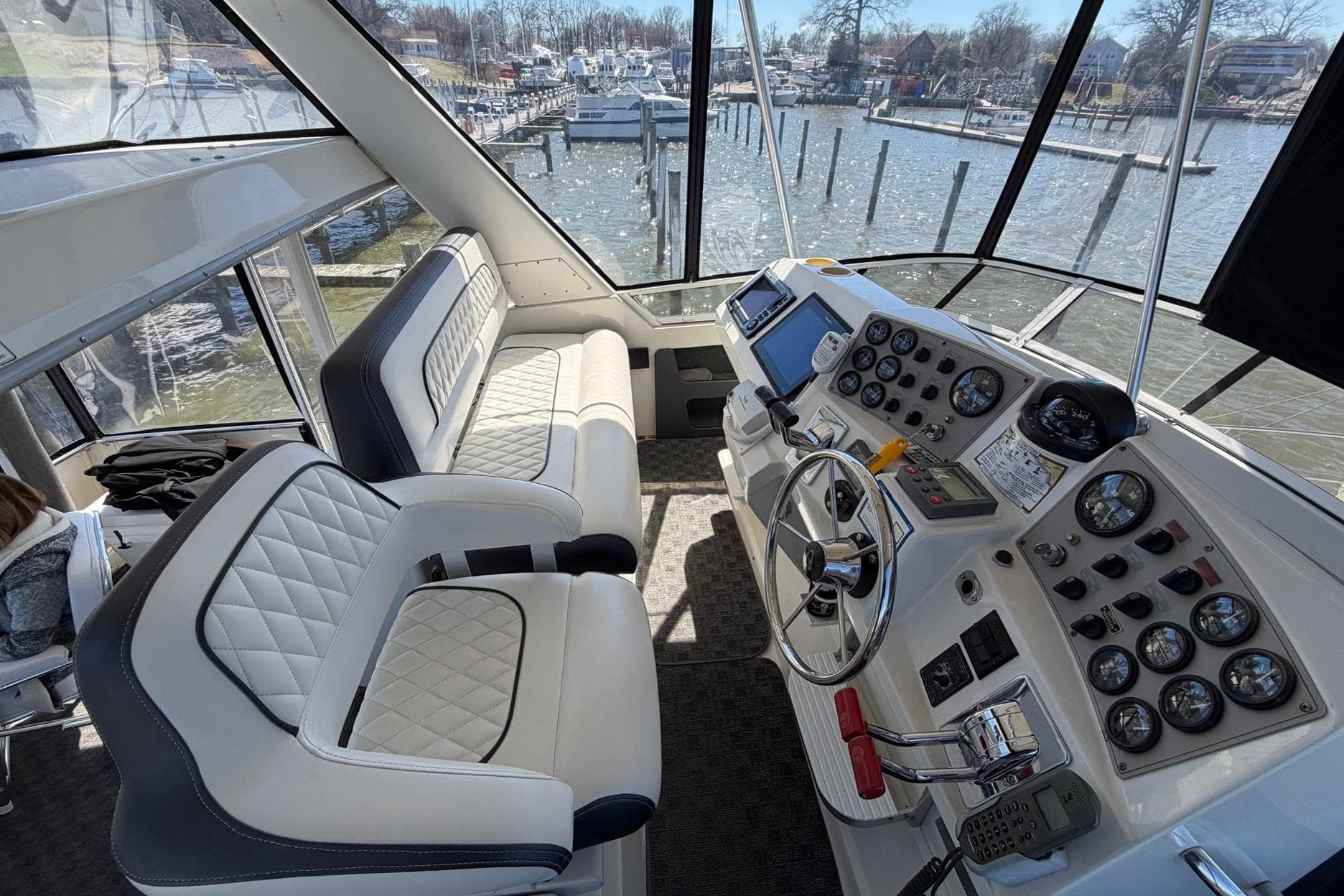 Interior view of 1997 Carver 400 Cockpit Motor Yacht helm with plush seating and control panel.