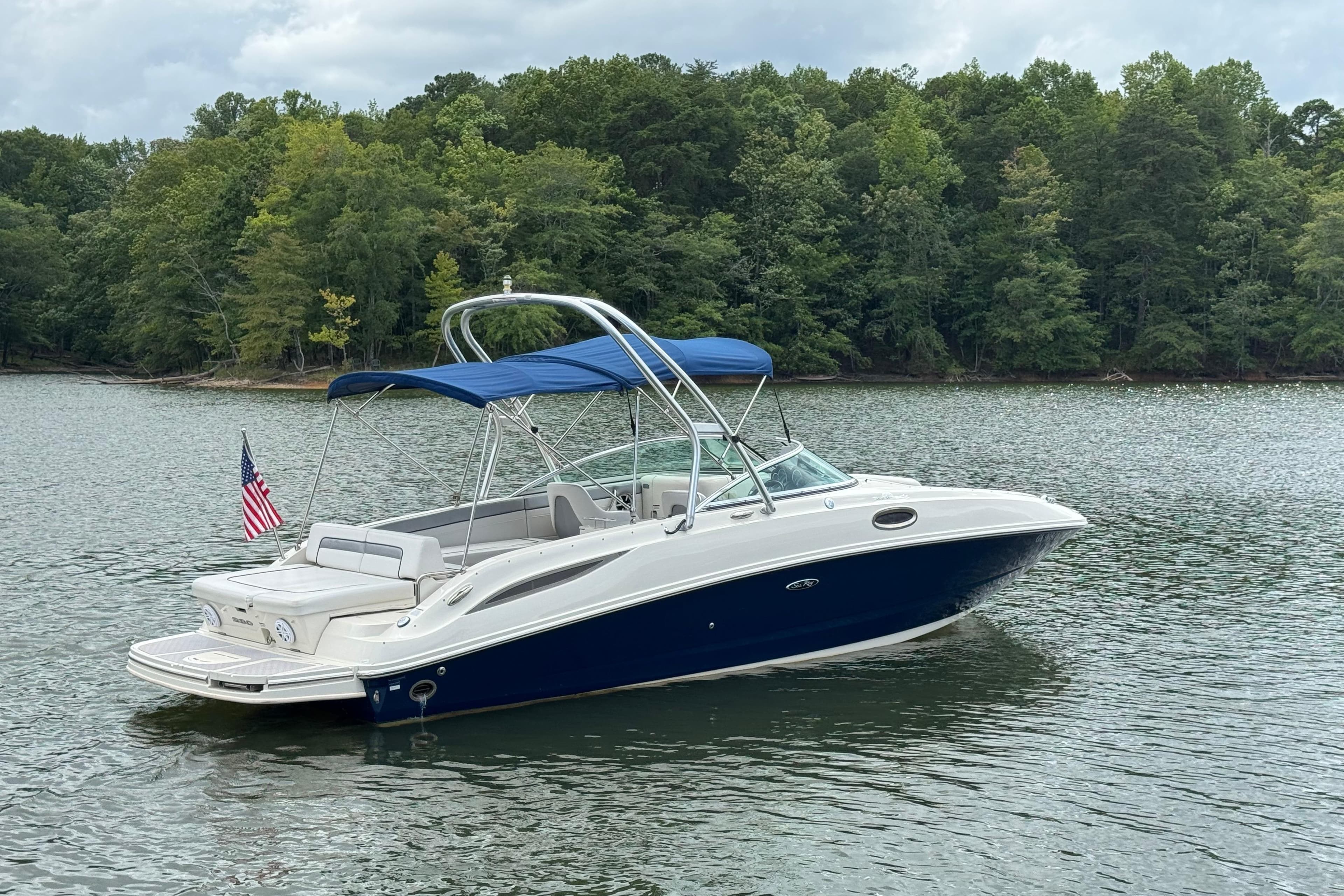 2009 Sea Ray 280 Sundeck boat on a calm lake with forested shoreline.