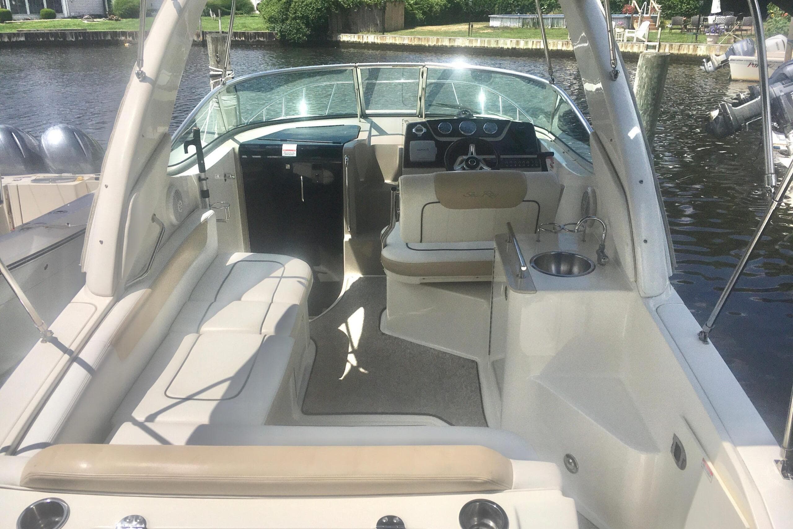 2010 Sea Ray 260 Sundancer boat interior with seating and helm, docked by the water.