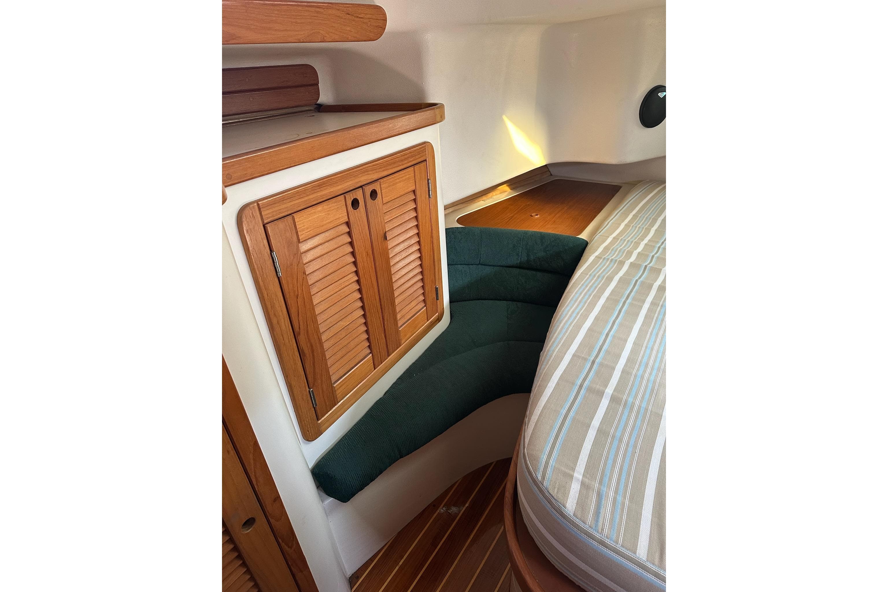 Interior of 1997 Catalina Morgan 38 sailboat with wooden cabinetry and cushioned seating.
