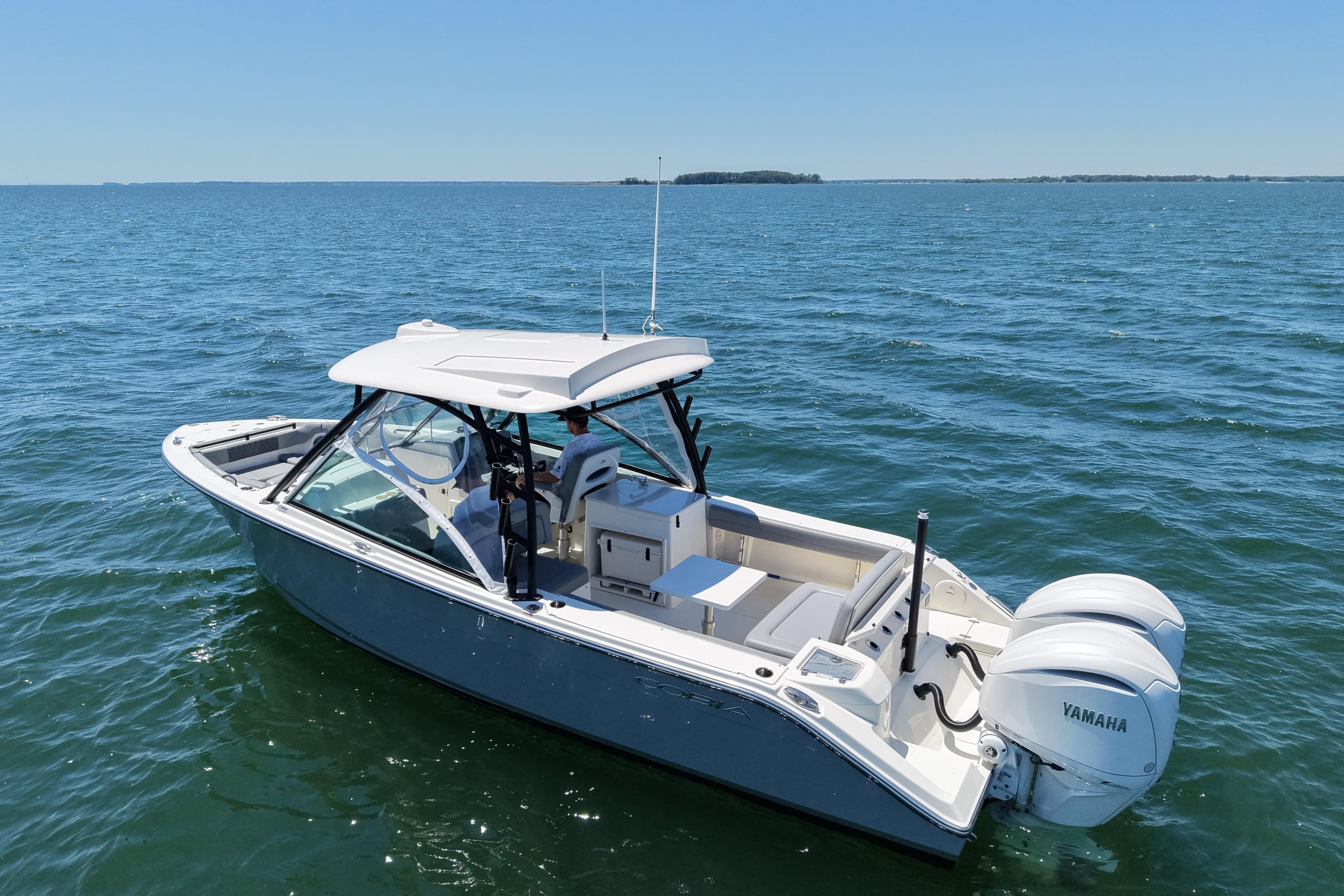 2024 Cobia 280 Dual Console boat on open water, featuring twin Yamaha engines.