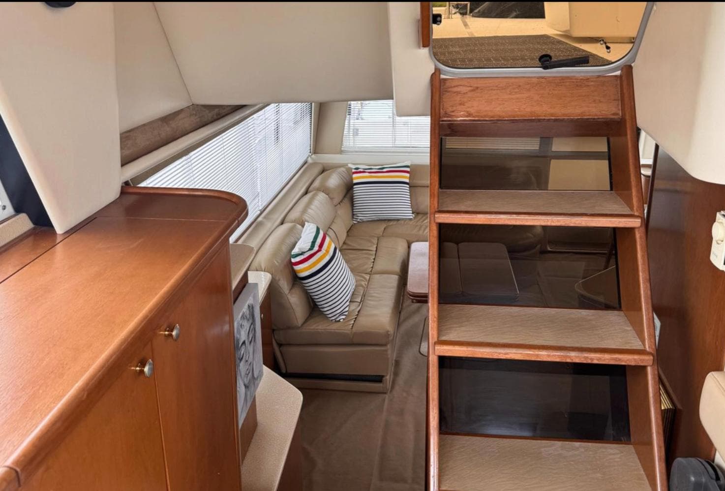 Interior of 2005 Meridian 490 Pilothouse with wooden stairs and cozy seating area.