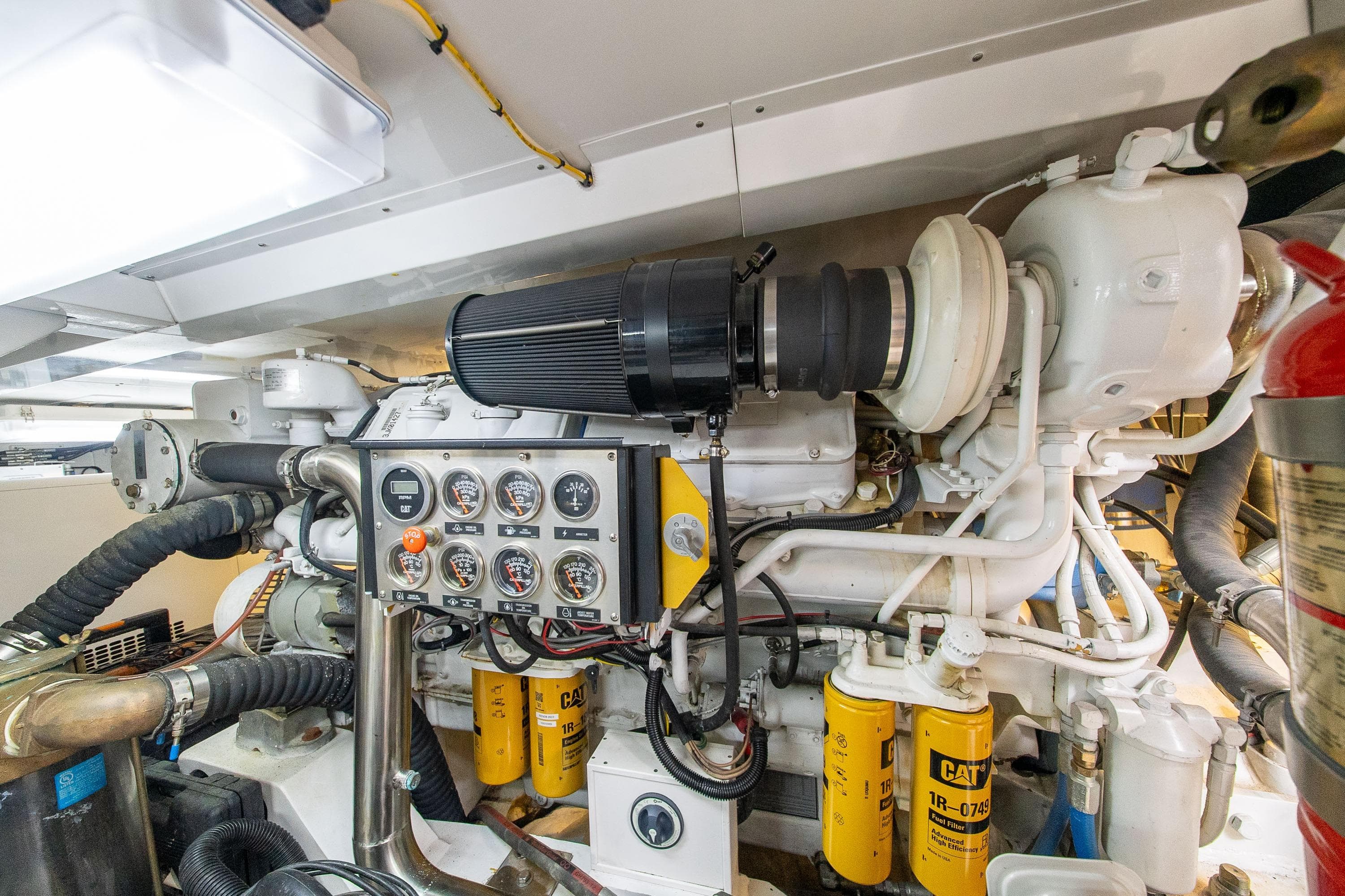 Engine room of 2002 Striker 76 Sportfish Motor Yacht with control panel and CAT filters.