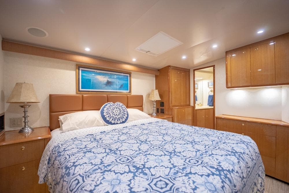 Luxurious bedroom interior of 2003 Viking 65 EB yacht with elegant wood cabinetry.