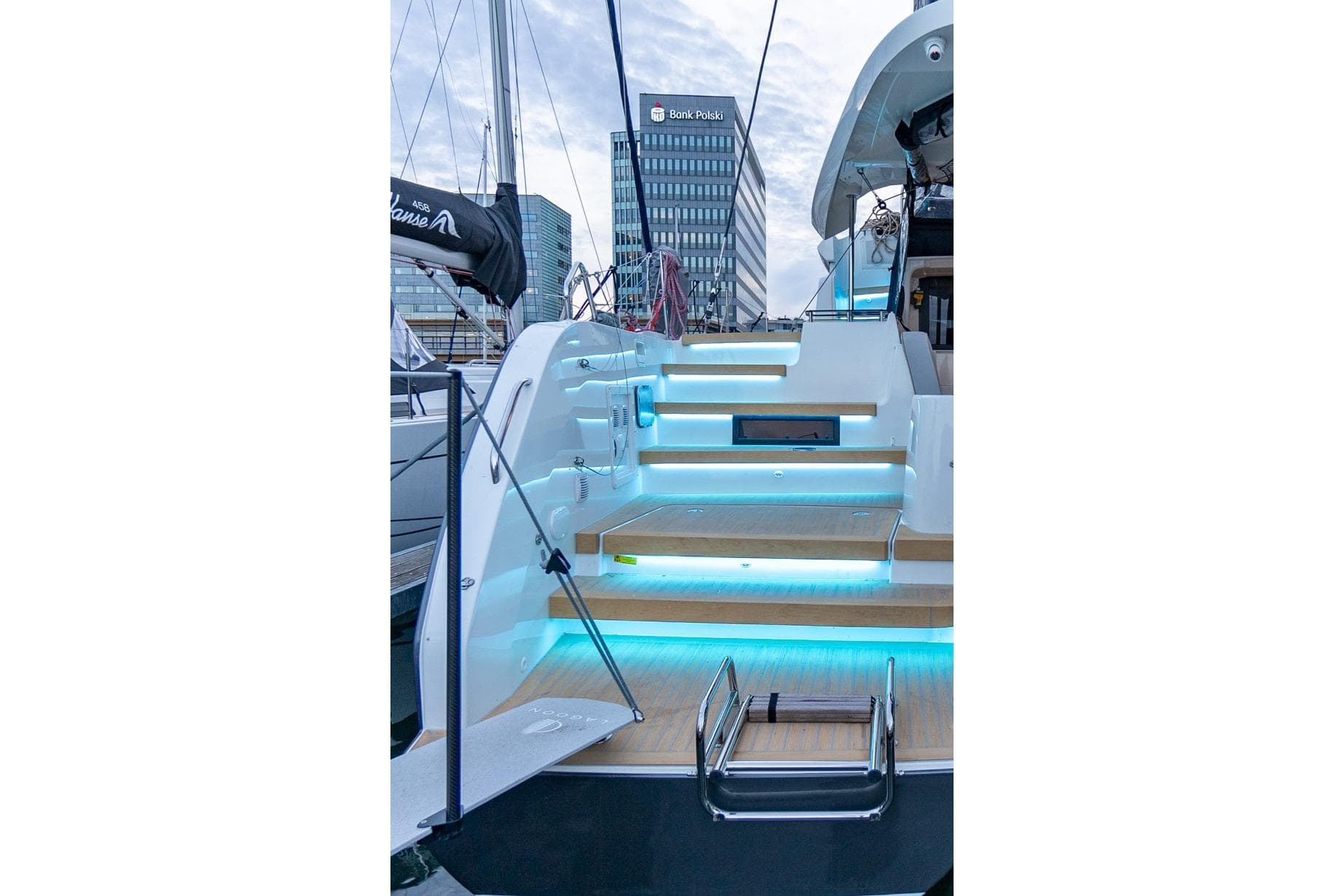2024 Lagoon 42 yacht with illuminated steps, docked in a modern marina setting.