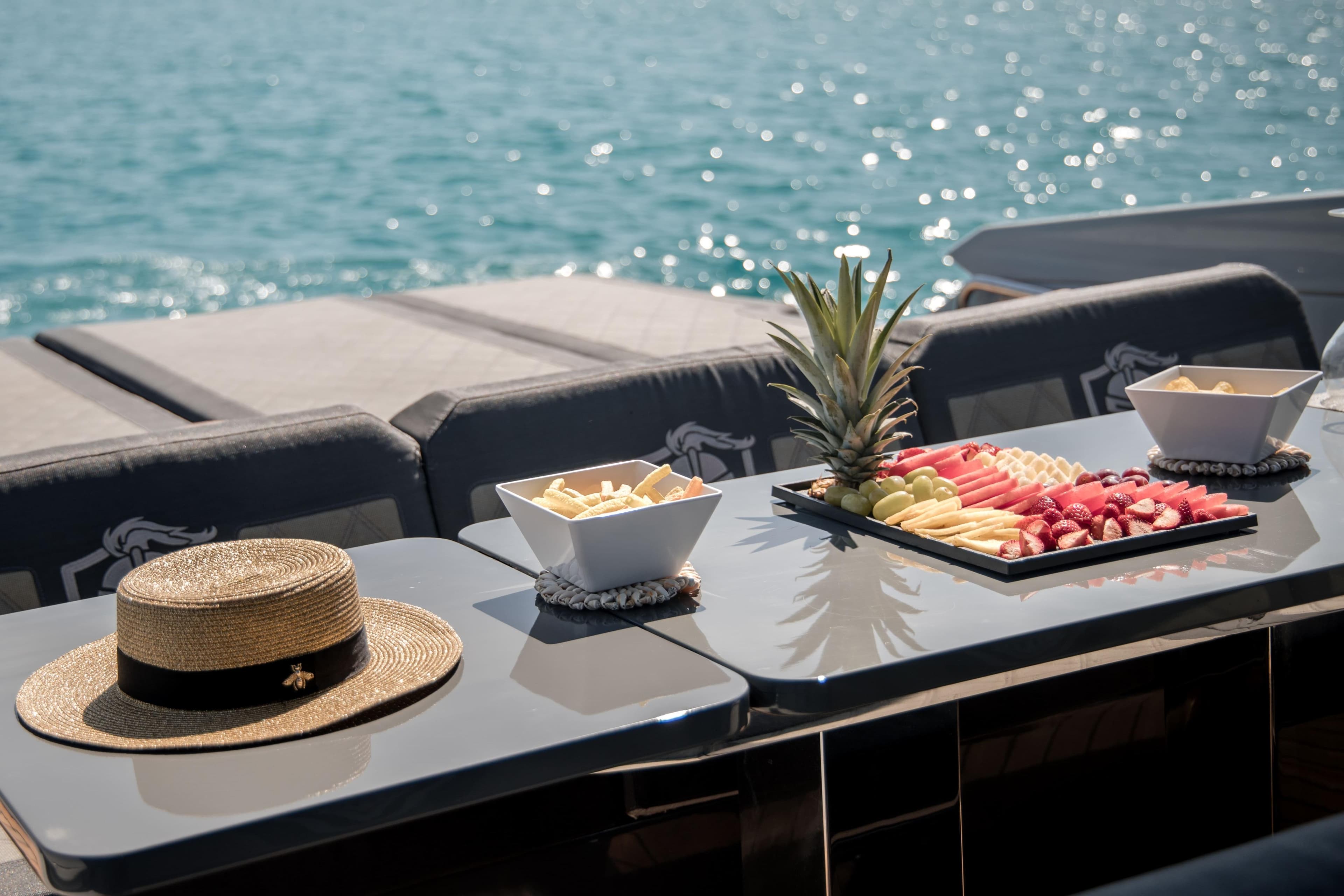Luxury yacht Canados Gladiator 493 with fruit platter and hat on deck, 2022 model.