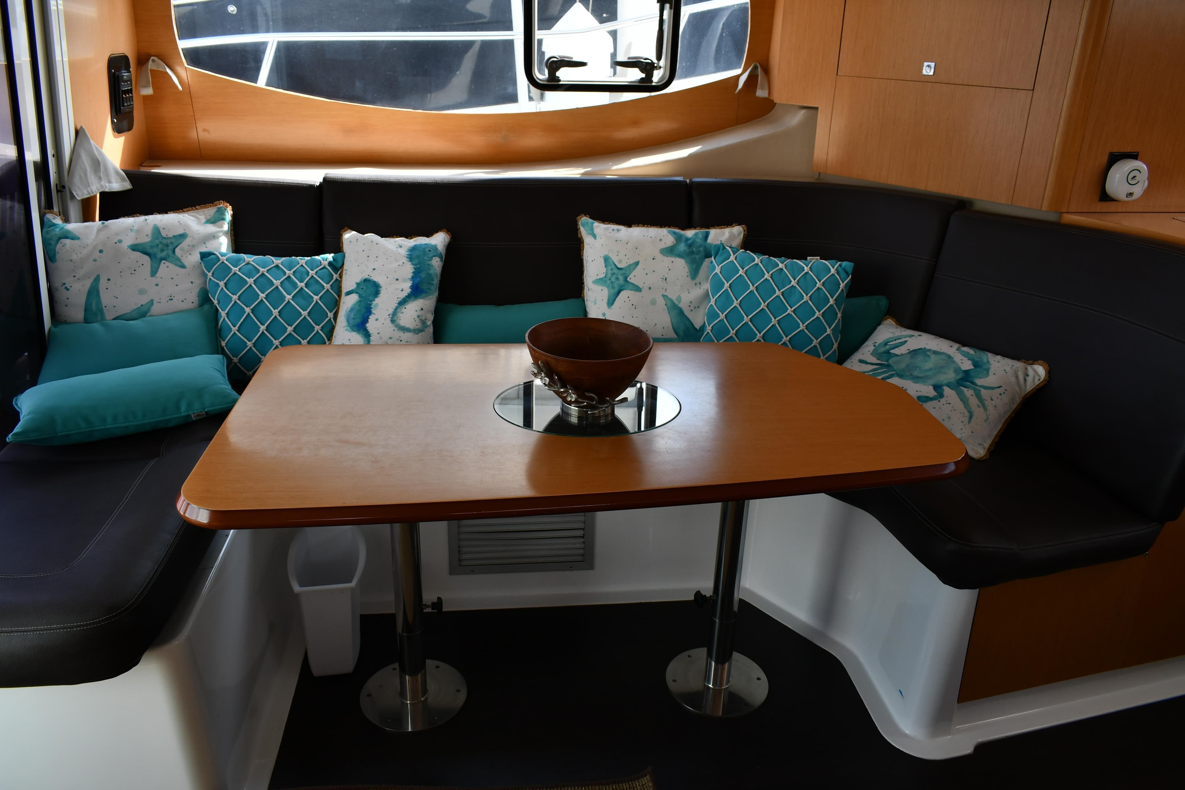 Interior of 2012 Fountaine Pajot 40 catamaran with cozy seating and decorative pillows.