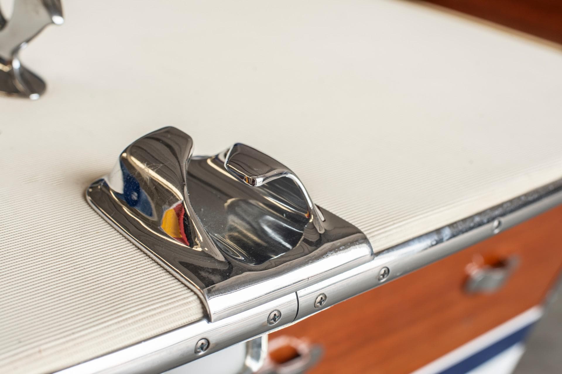 Close-up of a 1969 Riva Olympic boat's chrome cleat on a white deck.