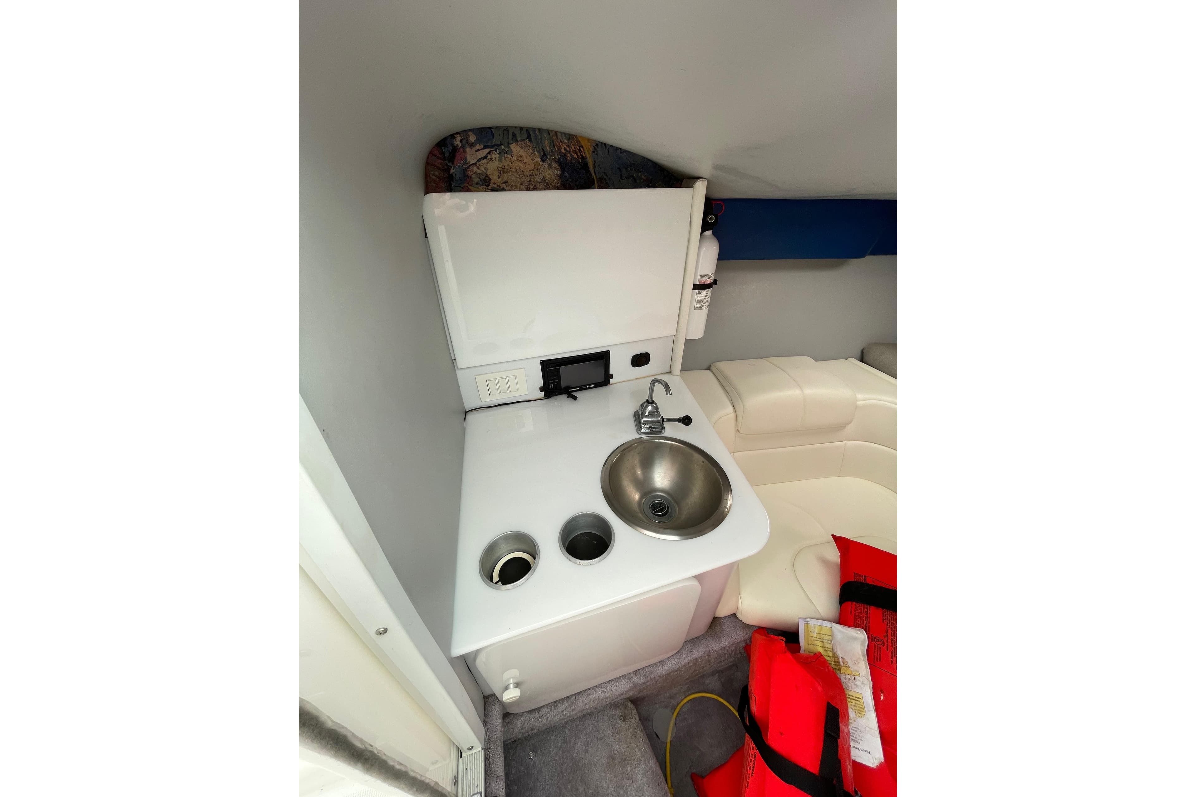 1999 Formula 271 FASTech cabin interior with sink, seating, and life jackets.