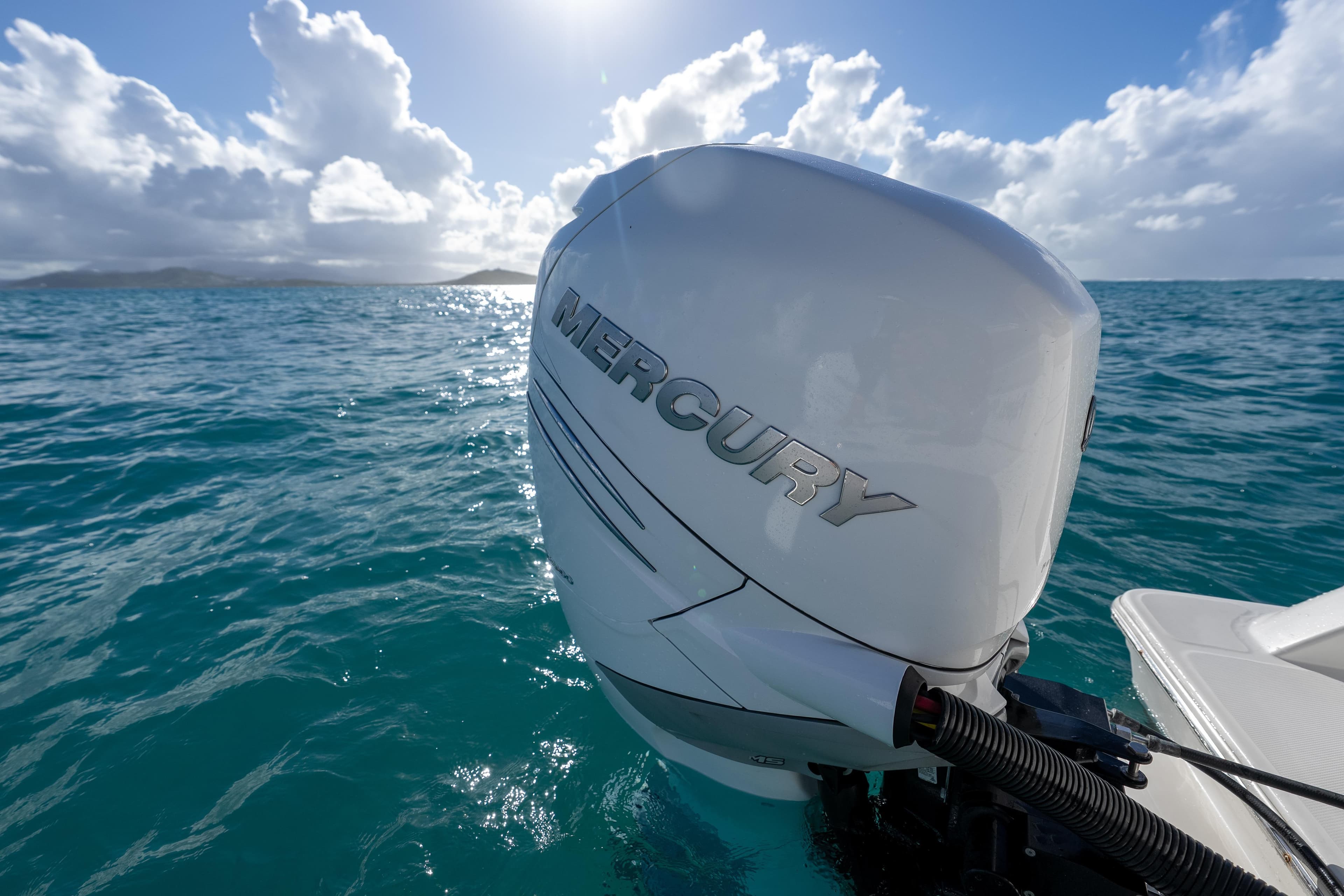 2023 Aquila 36 Sport with Mercury engine on turquoise ocean under blue sky.