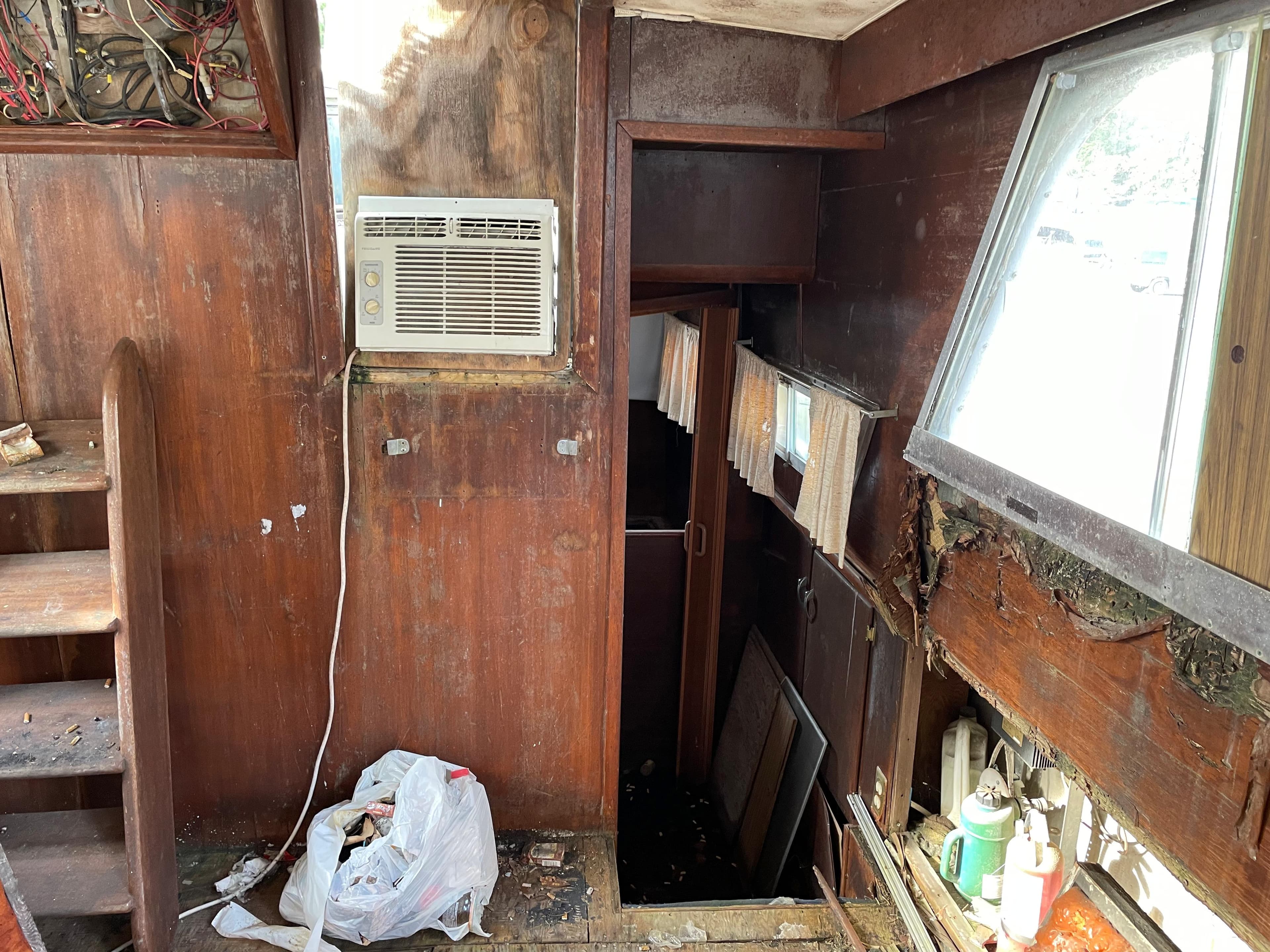Interior of a 1964 Hatteras Double Cabin boat with wooden walls and an air conditioner.