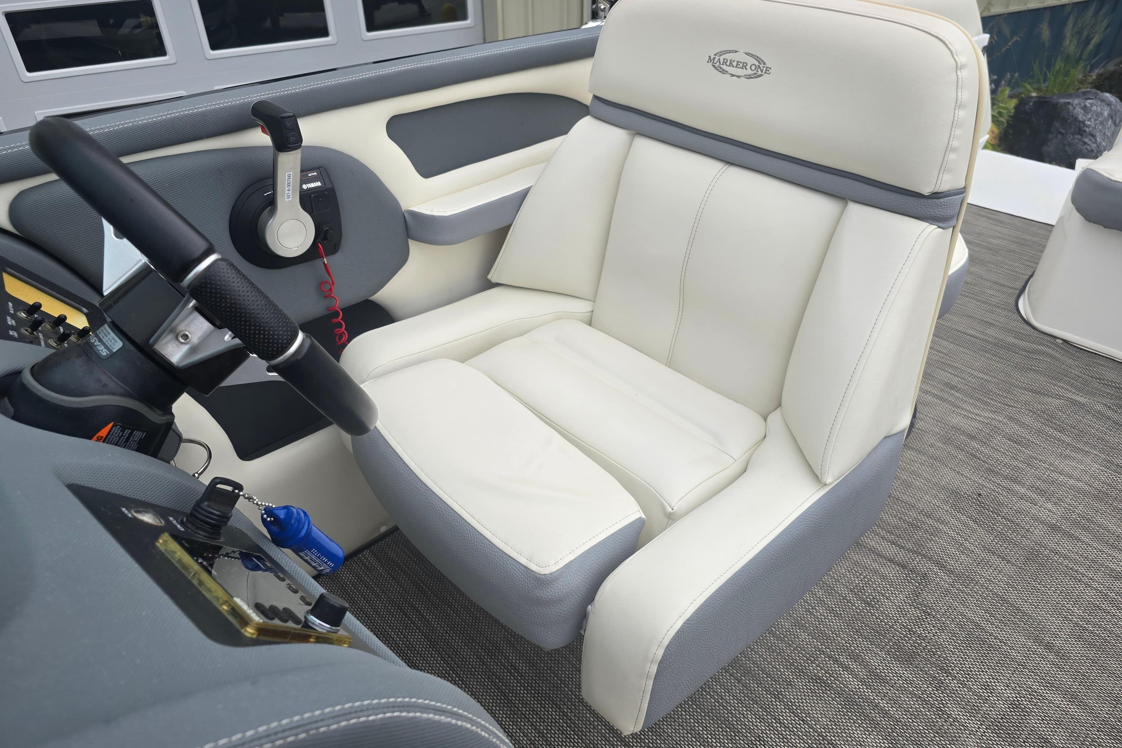 Captain's seat on 2016 Marker One ML4 boat, featuring plush white upholstery.