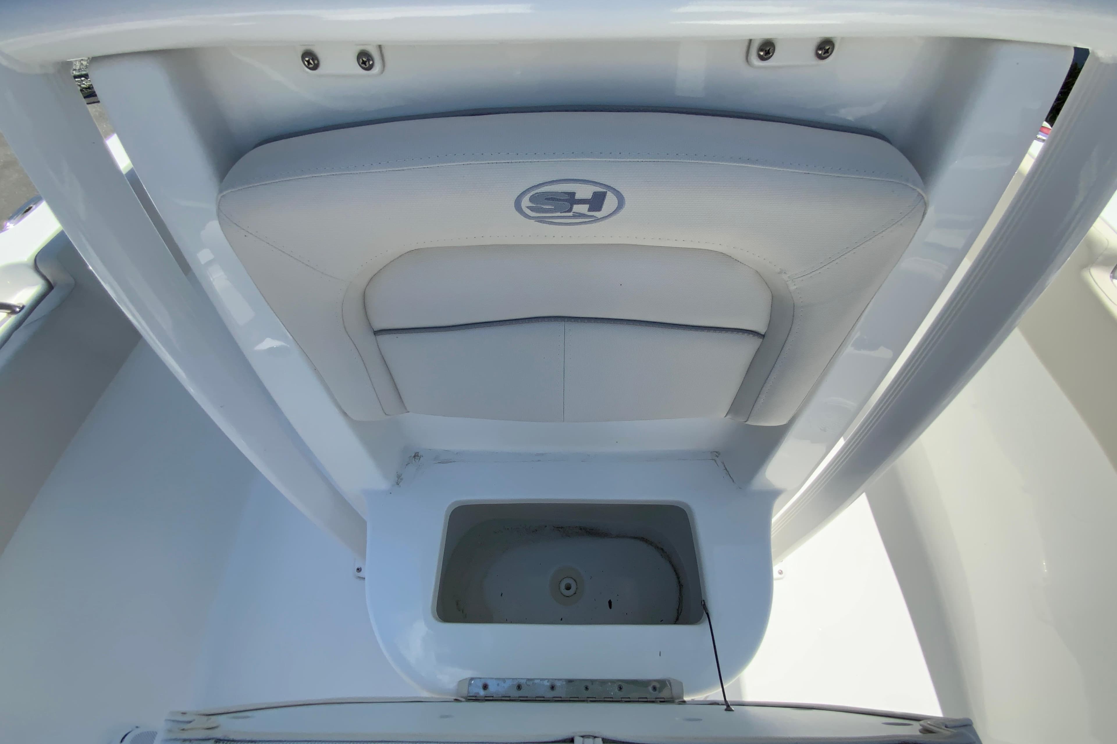2024 Sea Hunt Ultra 234 boat seat and storage compartment, featuring sleek white design.