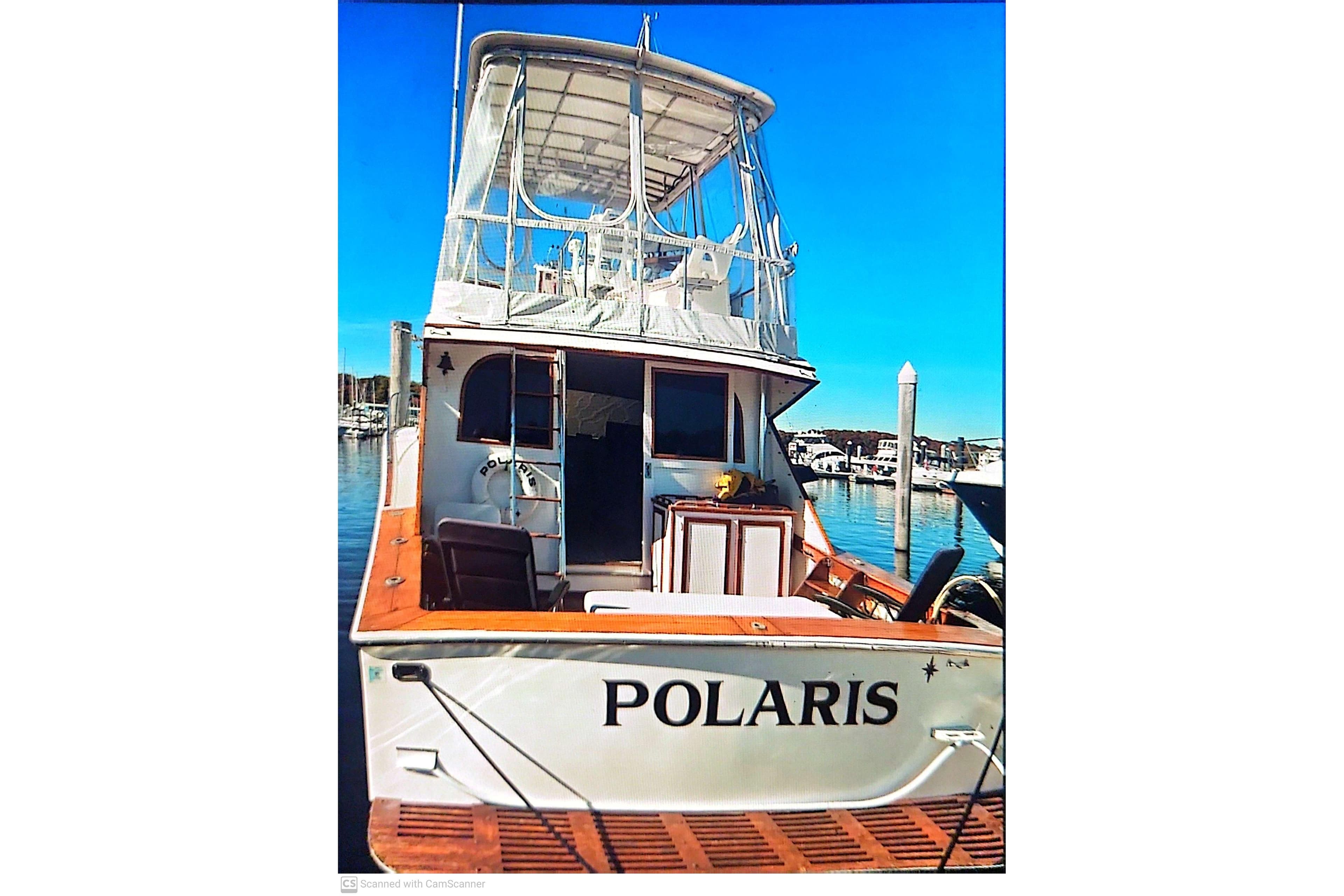 1977 Post Sport Fish boat "Polaris" docked at marina under clear blue sky.