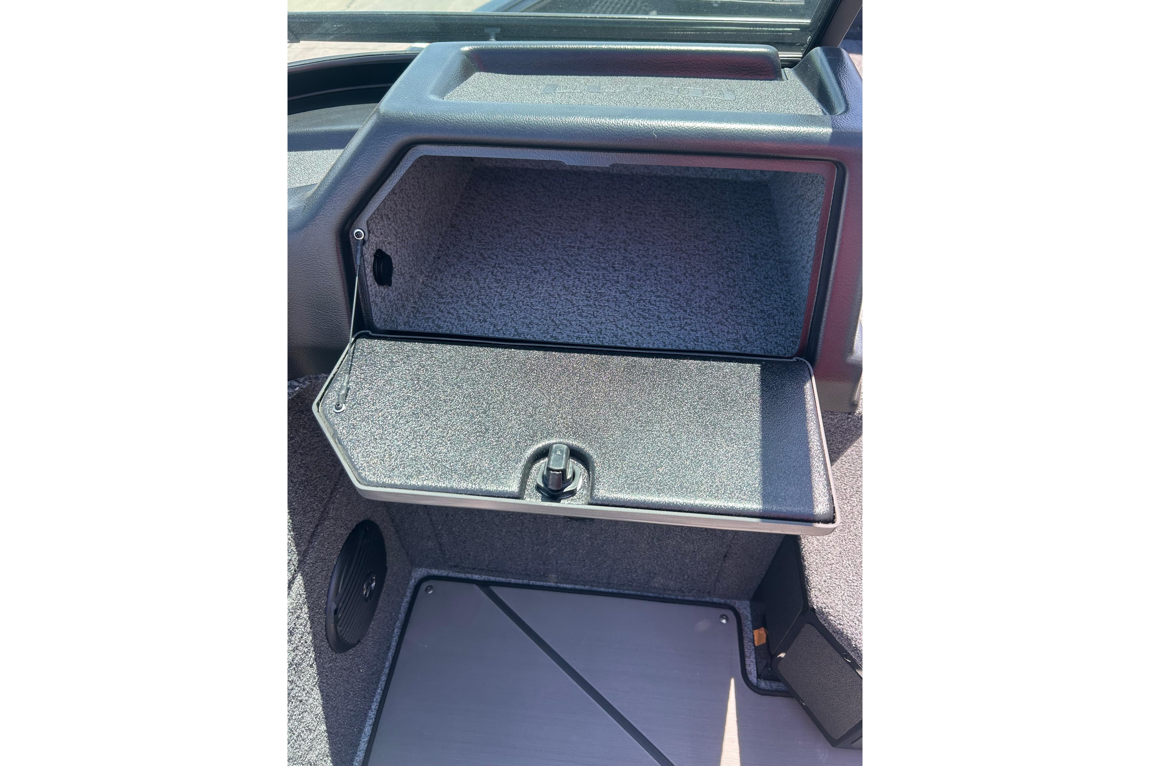 2026 Lund 1875 Impact XS Sport boat storage compartment, open and empty.