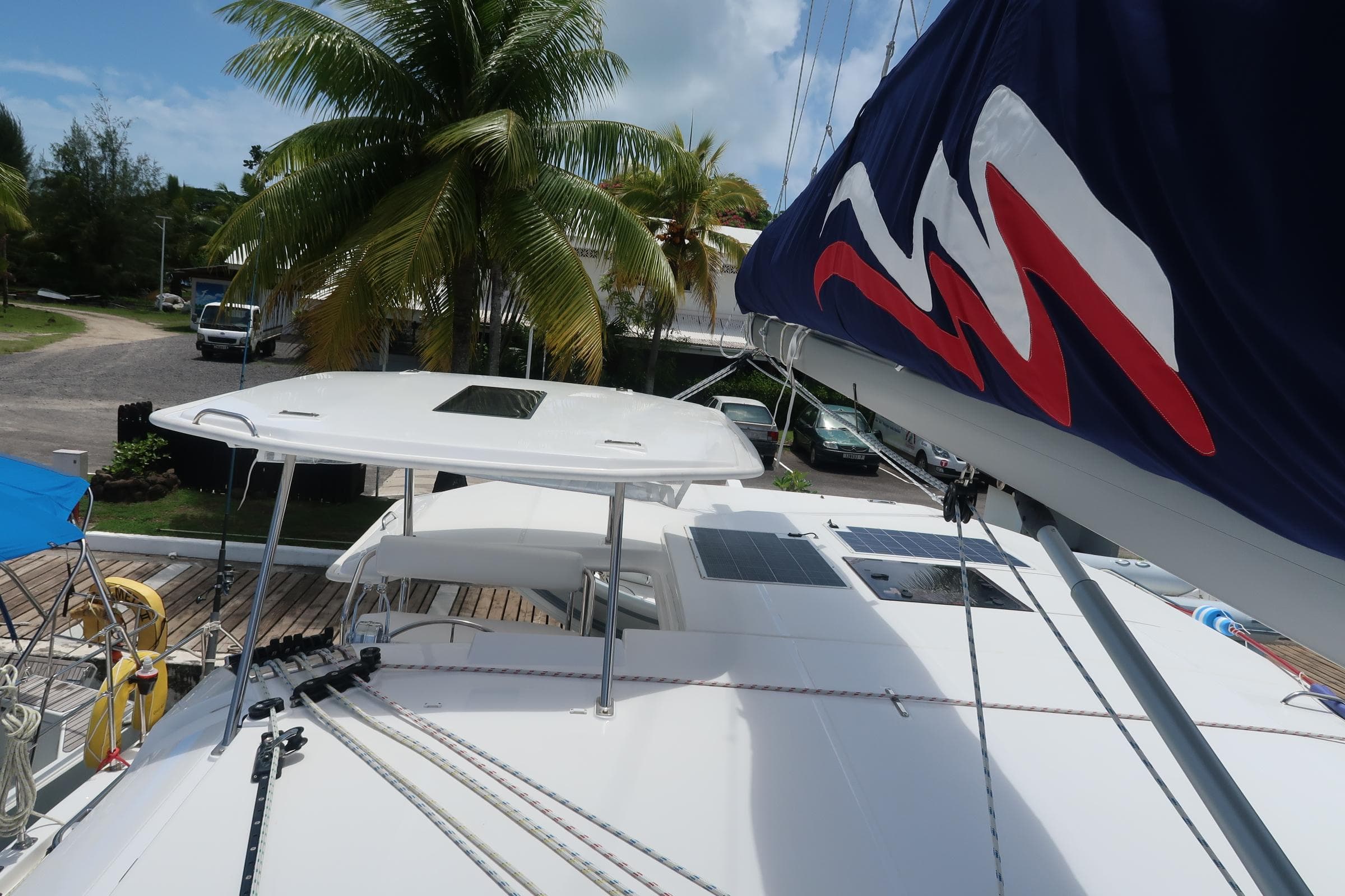 2019 Leopard 40 catamaran docked, featuring sails and deck, surrounded by tropical scenery.