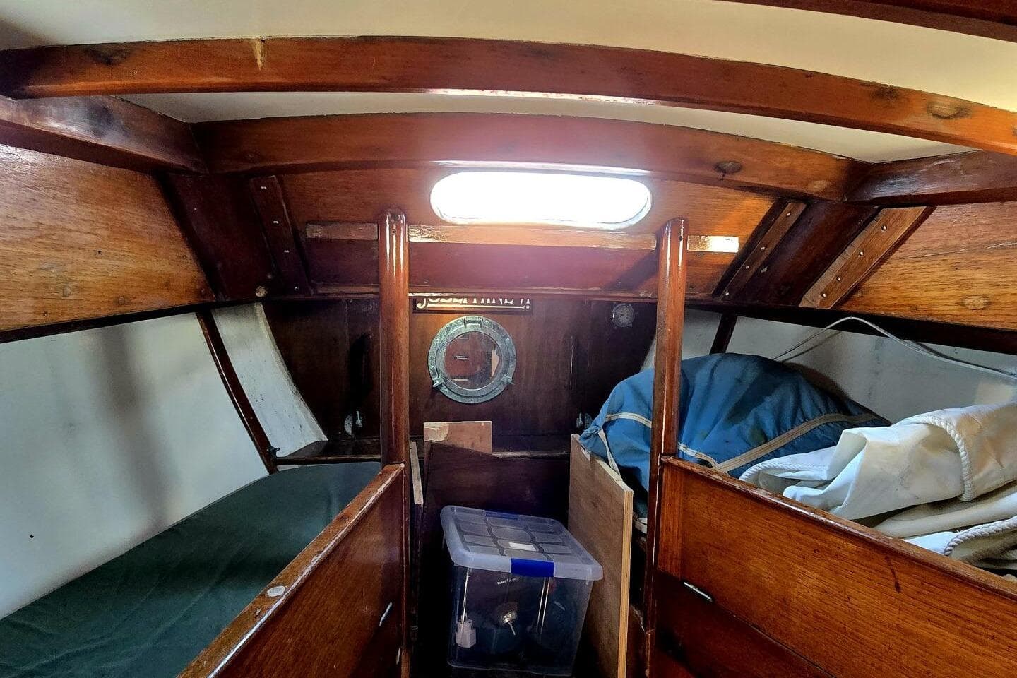 Interior of a 1964 Camper & Nicholsons 36 sailboat with wooden finishes and storage.